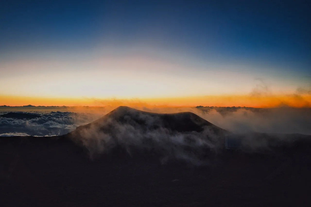 Breathtaking Mauna Kea Sunset: Fiery Glow Over Cloud-Kissed Peaks