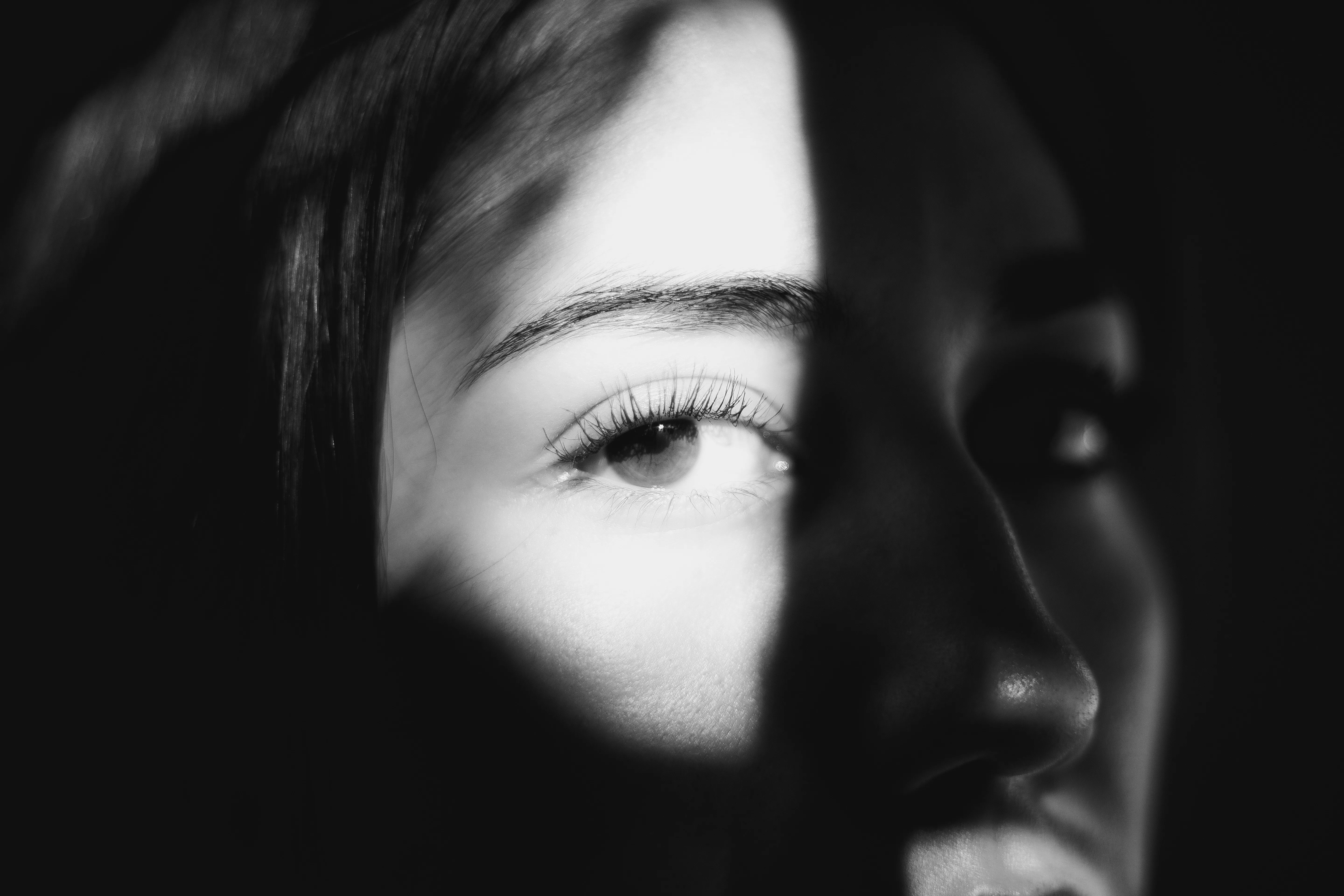 Striking Black and White Portrait: Enigmatic Gaze in Shadow