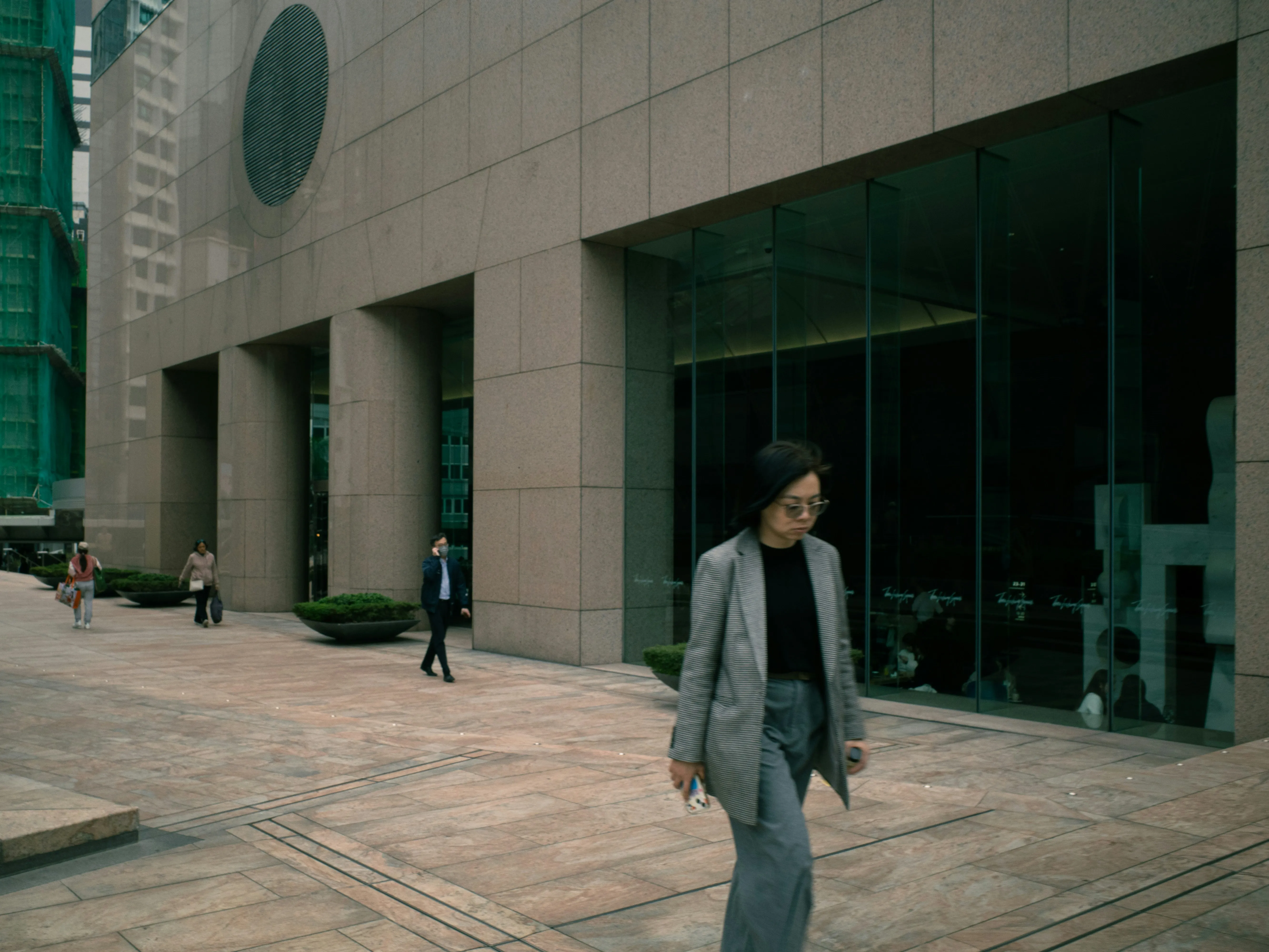 Urban Serenity: Woman Strolls Past Modern Architecture