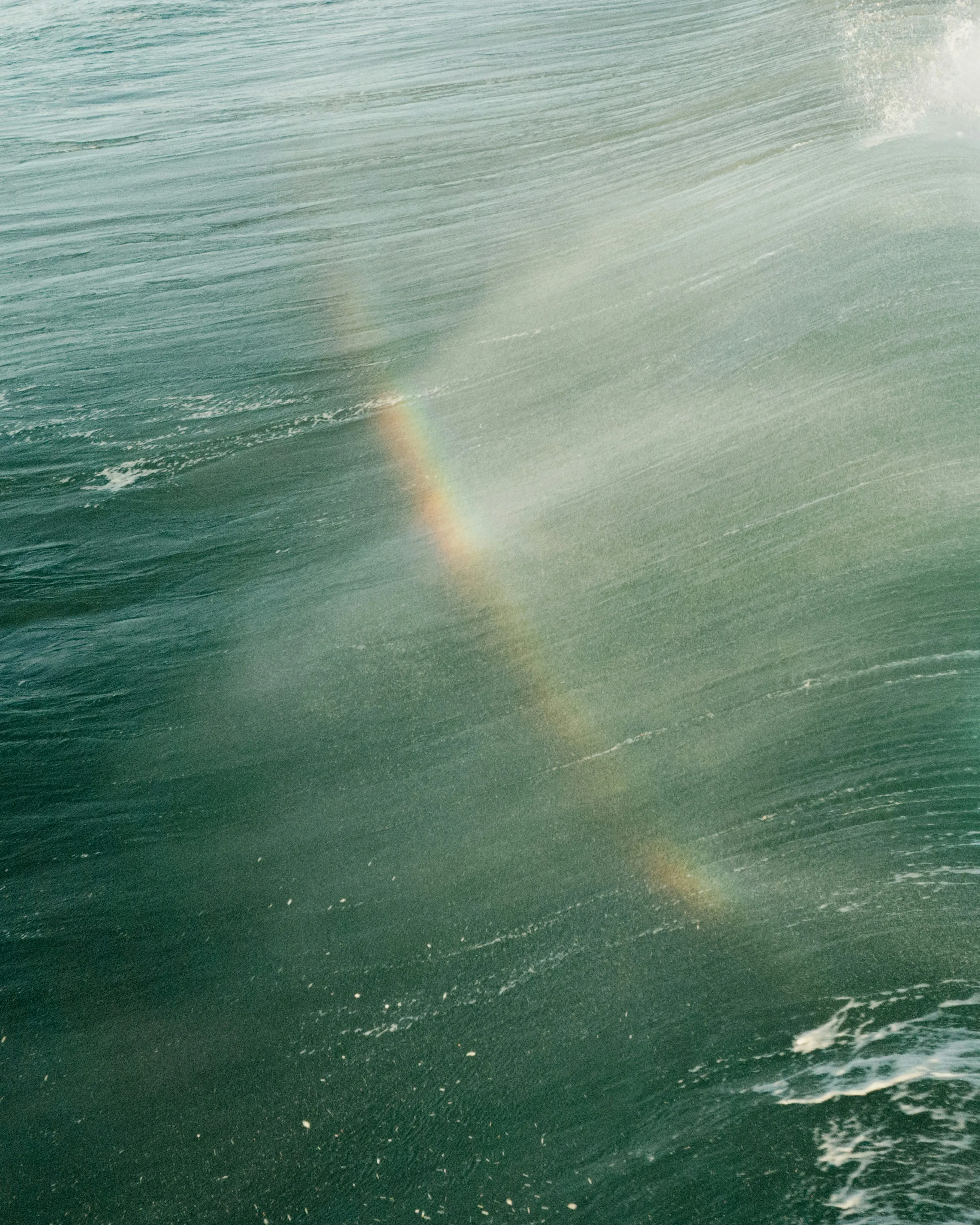 Stunning Ocean Rainbow: A Moment of Breaking Wave Serenity