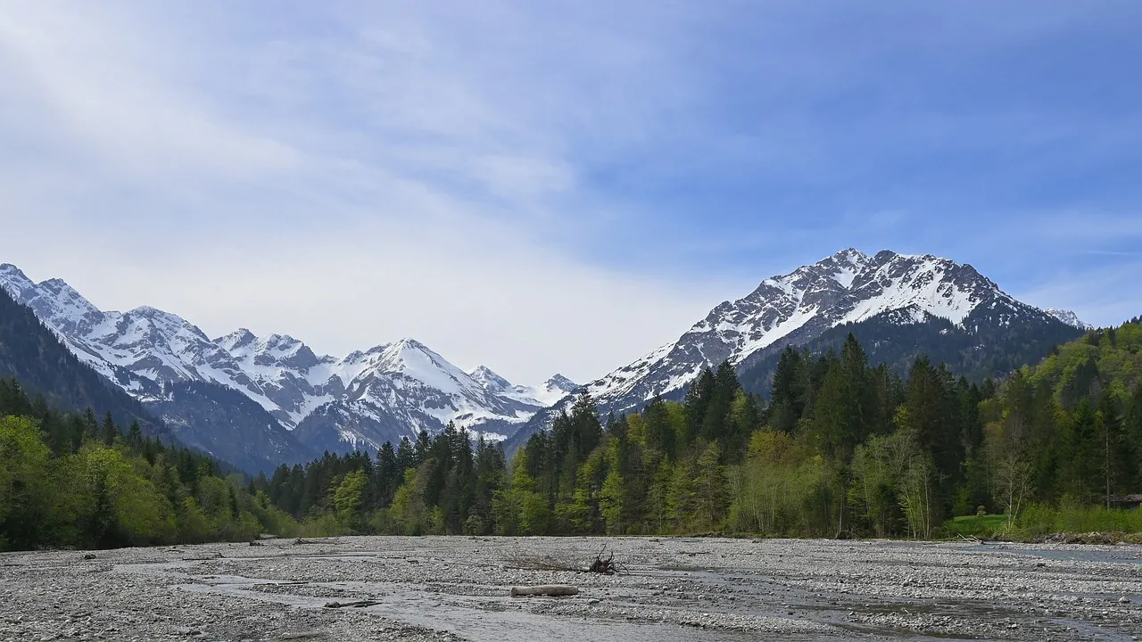 Majestic Alpine Peaks: Serene River Valley Vista