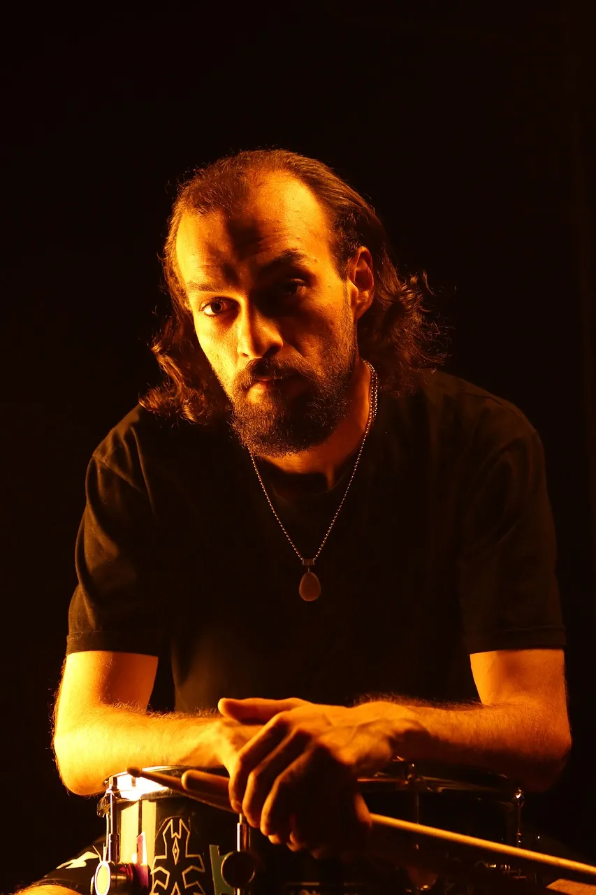 Intense Gaze: Drummer in Dramatic Orange Light