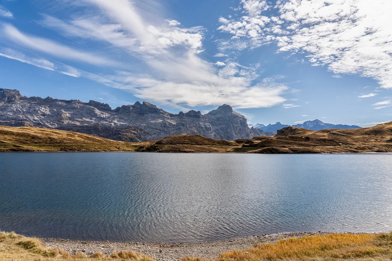 Breathtaking Alpine Panorama: Serene Lake Amidst Autumn Peaks