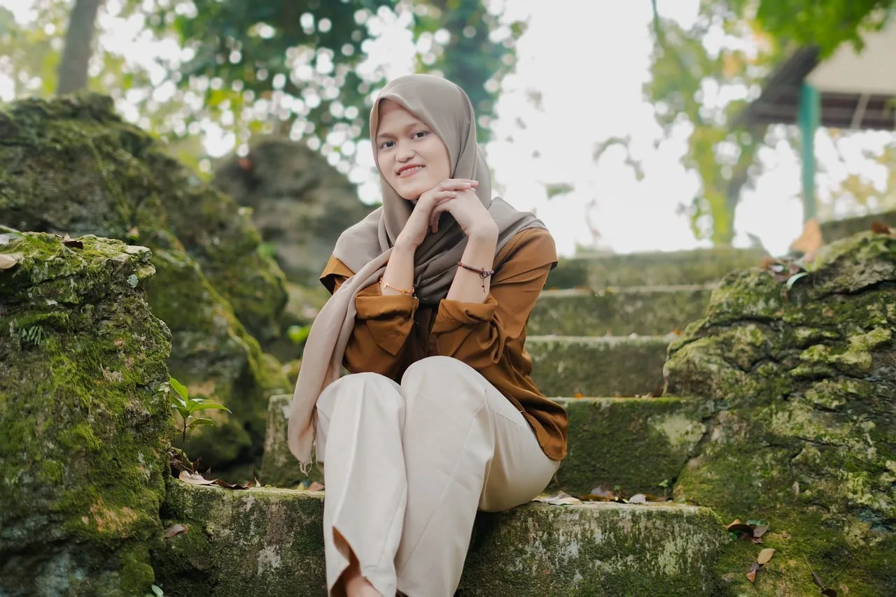 Serene Muslim Woman in Hijab Graces Mossy Stone Steps