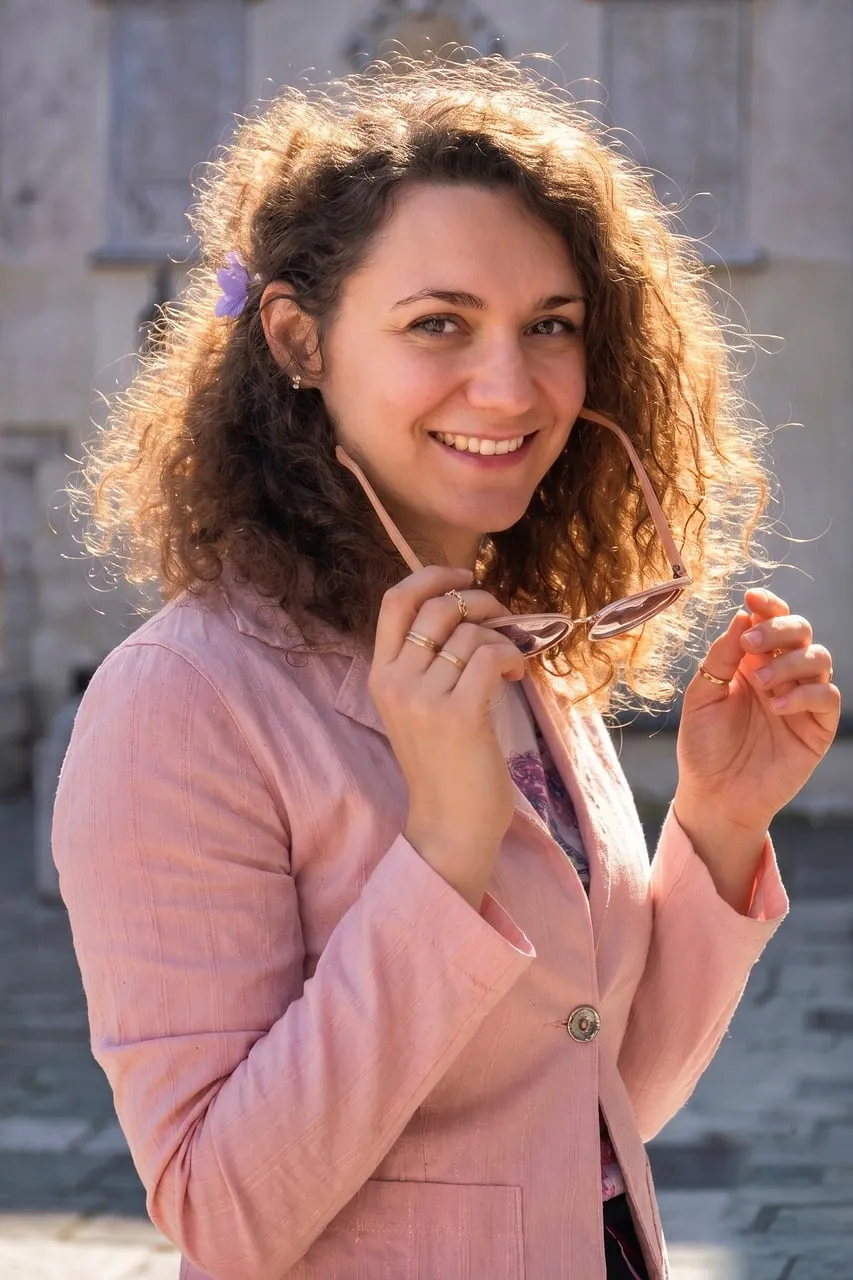 Radiant Joy: Sun-Kissed Woman with Curly Hair and Floral Charm