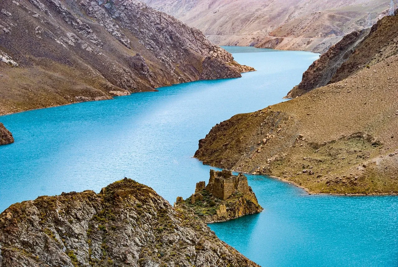 Azure Tibetan Reservoir: Ancient Ruins Amidst Majestic Mountains