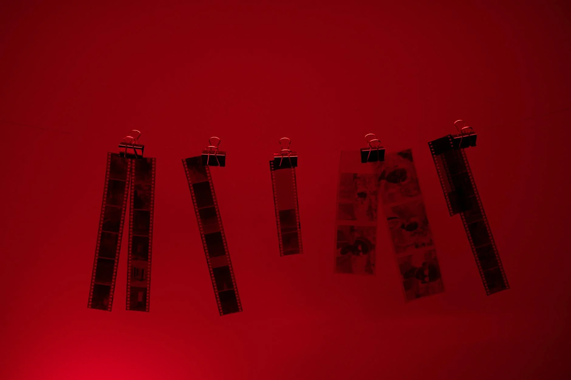 Dramatic Red Glow: Vintage Film Strips Drying in Darkroom