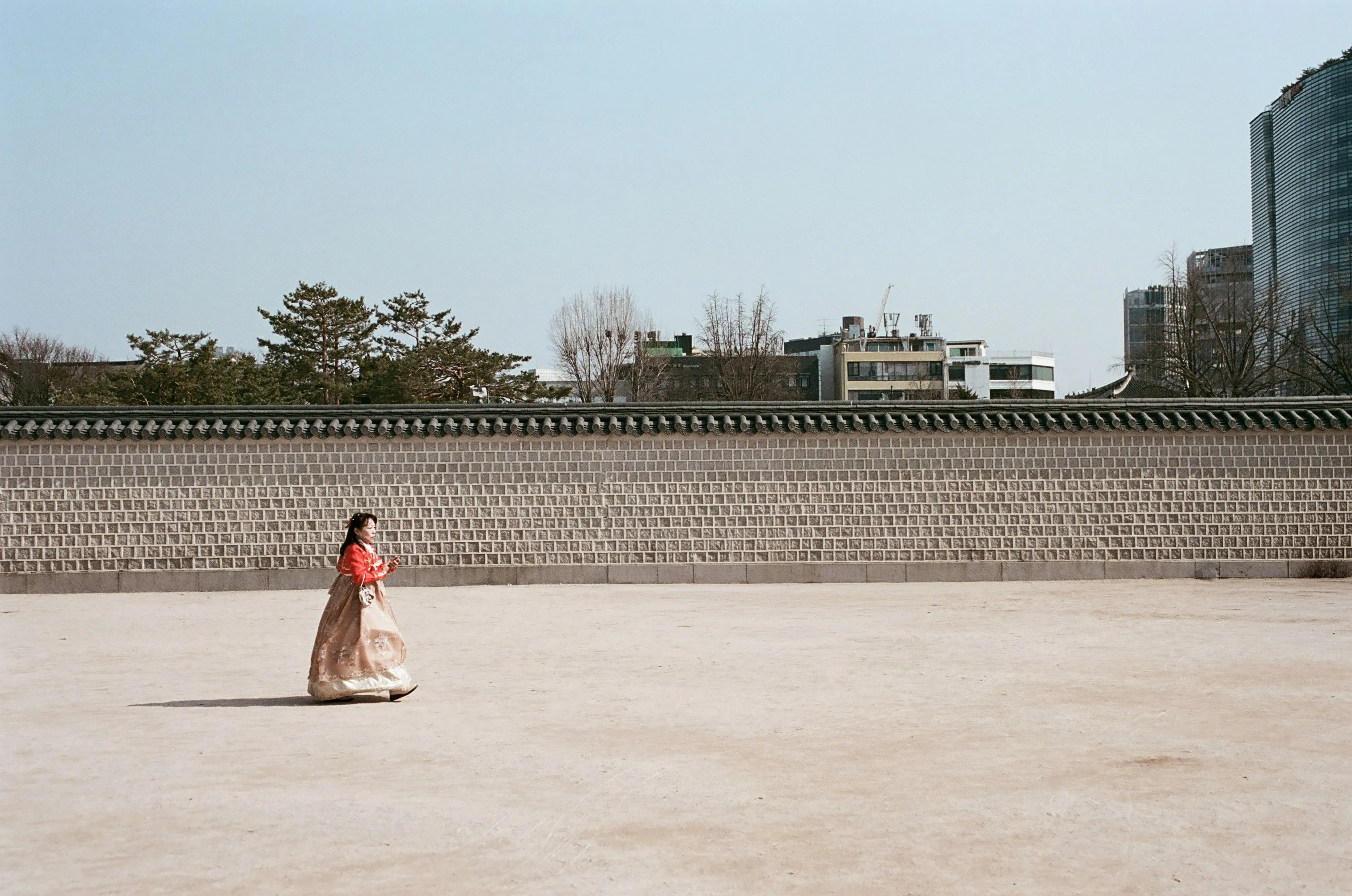 Graceful Hanbok: Woman Strolling by Ancient Stone Wall