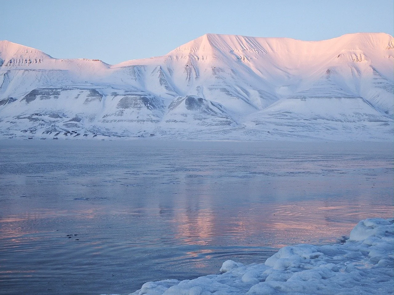 Arctic Majesty: Pink Sunset on Snowy Fjord Mountains