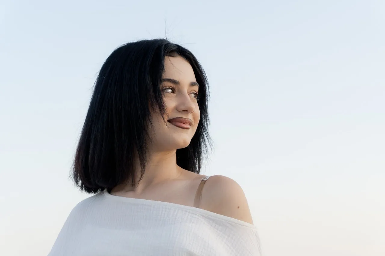 Serene Brunette Portrait: Natural Beauty Under Clear Skies
