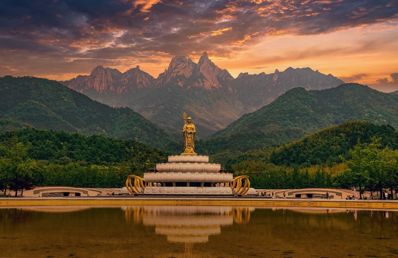 Serene Sunset: Golden Buddha Reflects Mountain Majesty