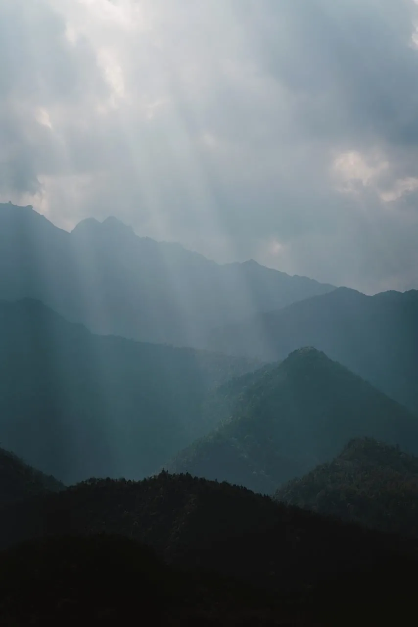 Mystical Sunbeams Pierce Hazy Mountain Ridges