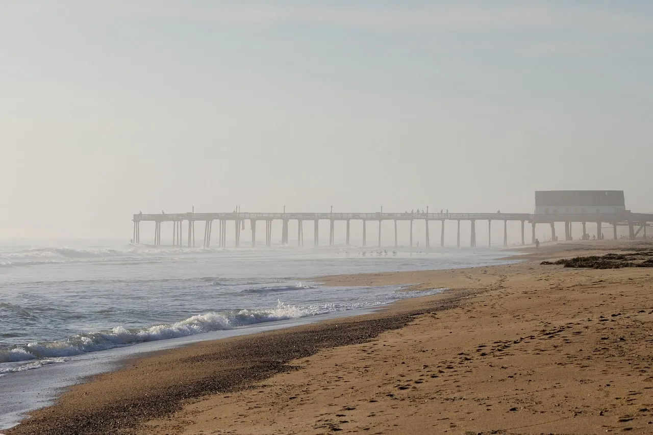 Misty Morning Ocean: Tranquil Pier and Waves at Dawn