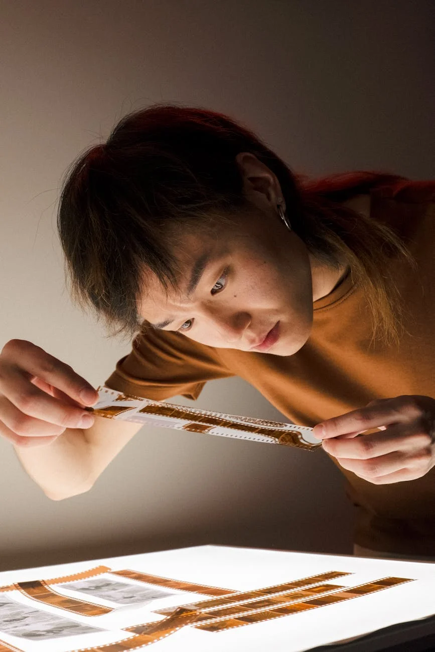 Captivating Gaze: Young Man Scrutinizing Film Negatives