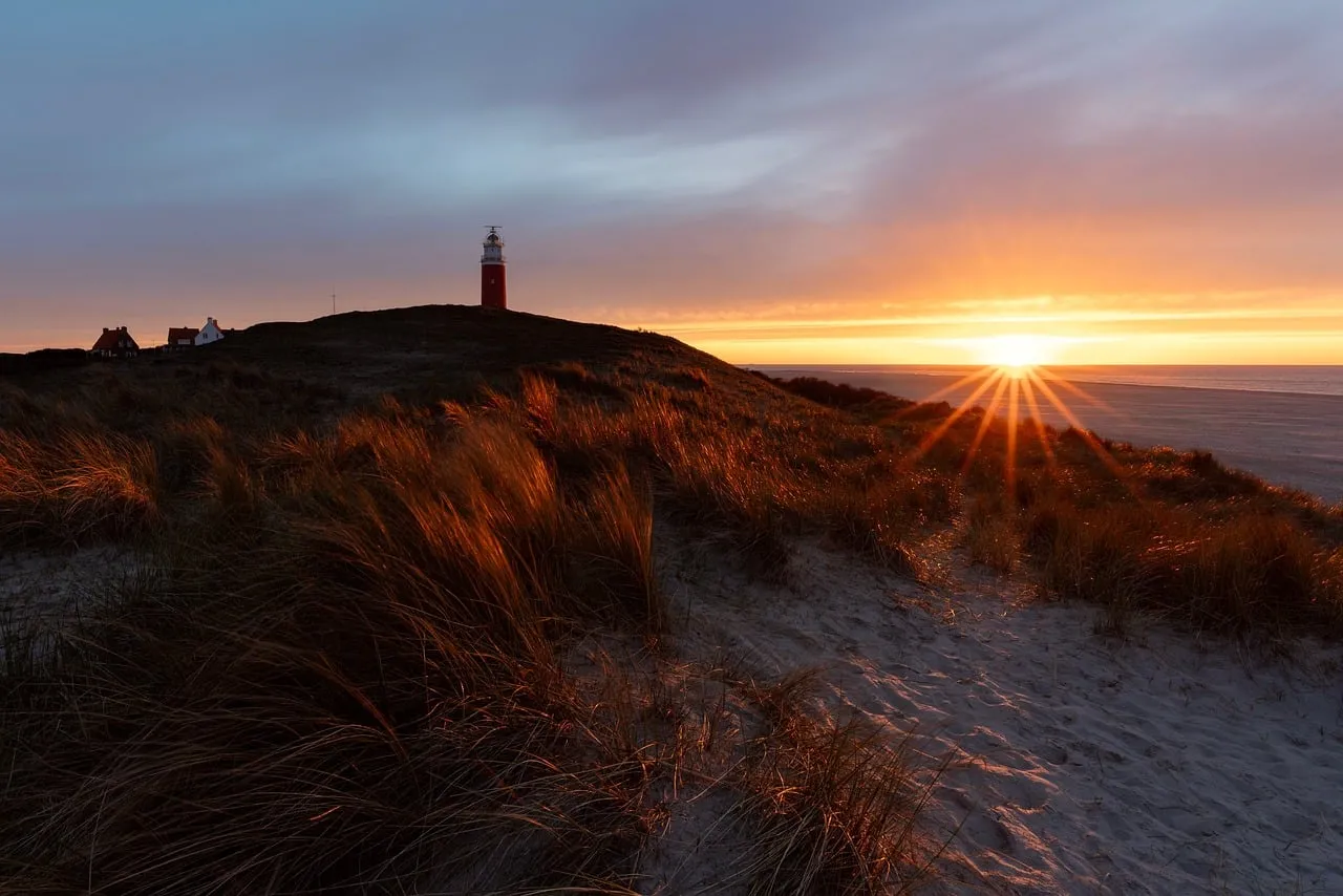 Dramatic Texel Sunset: Lighthouse Guardian Over Shimmering Dunes