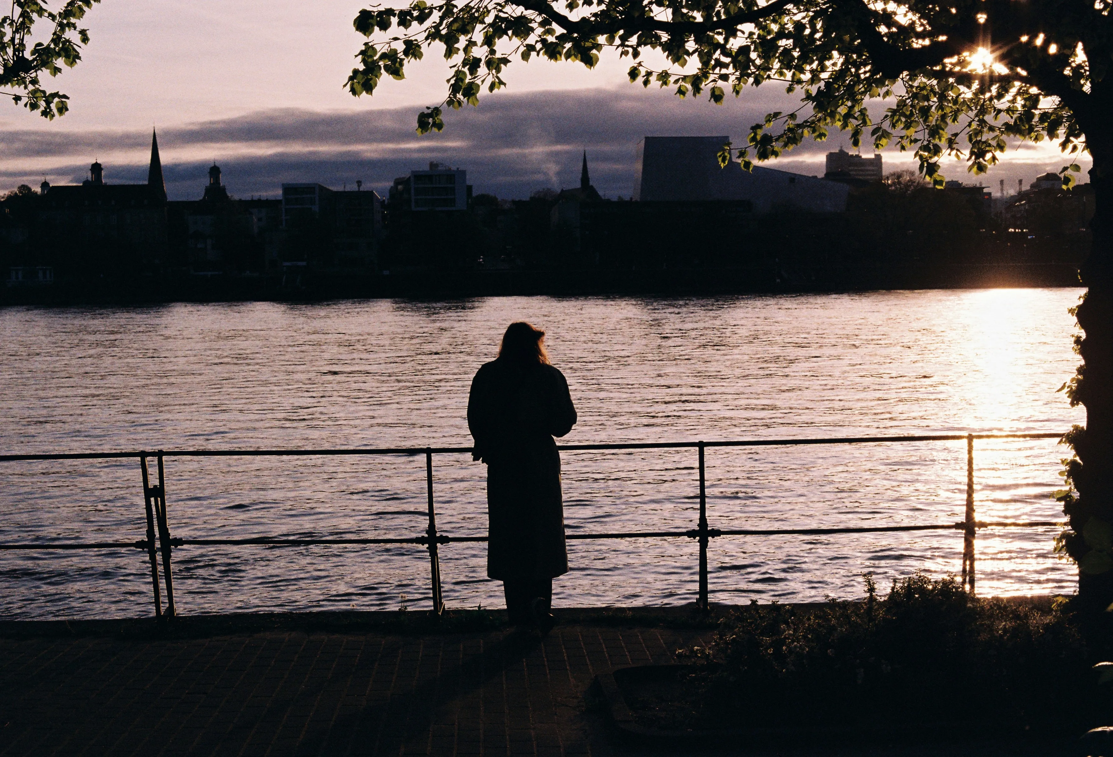 Enchanting Dusk: Solitary Figure Gazing at City Sunset