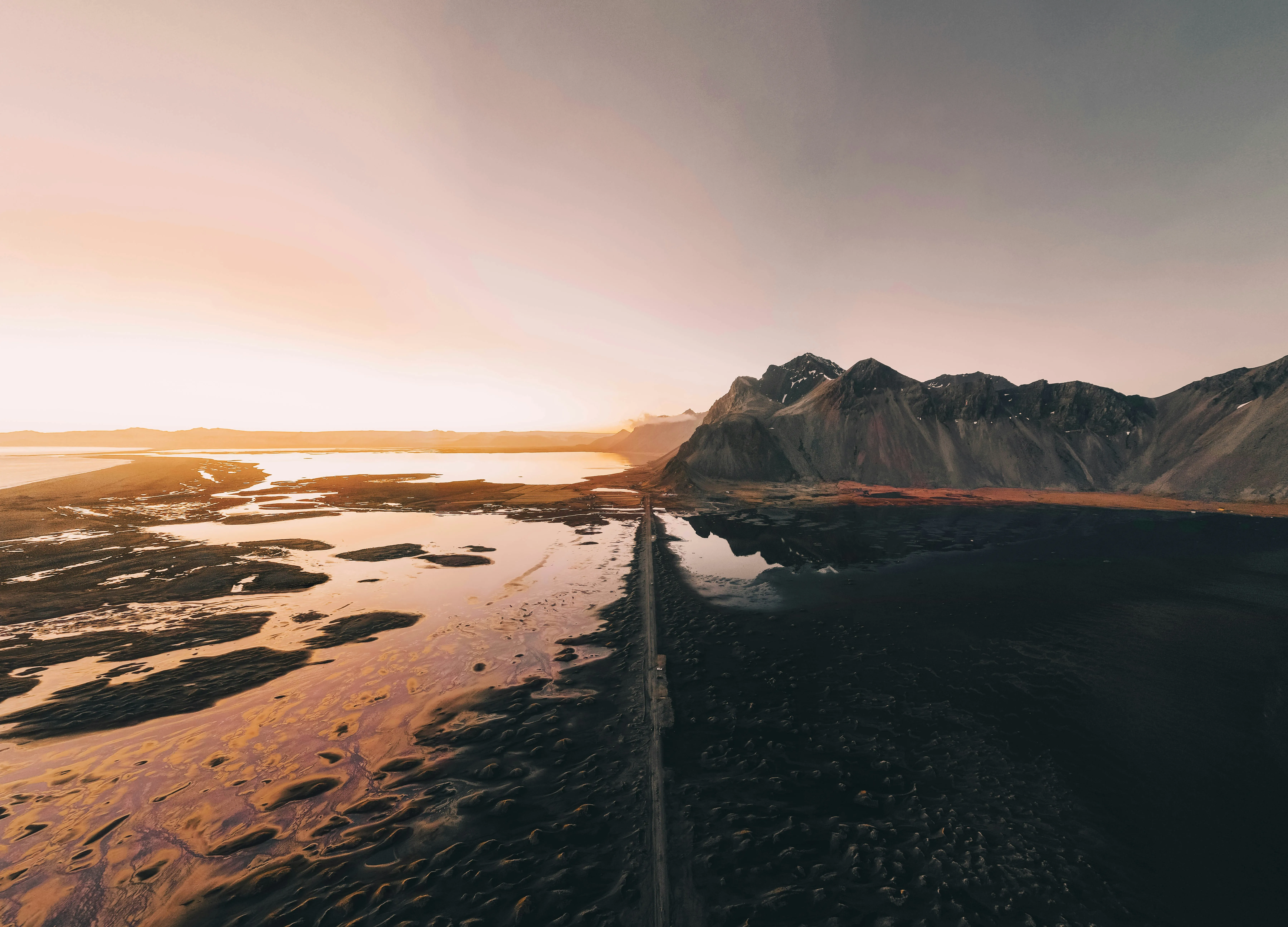 Dramatic Coastal Mountain Landscape with Reflective Waters at Sunset