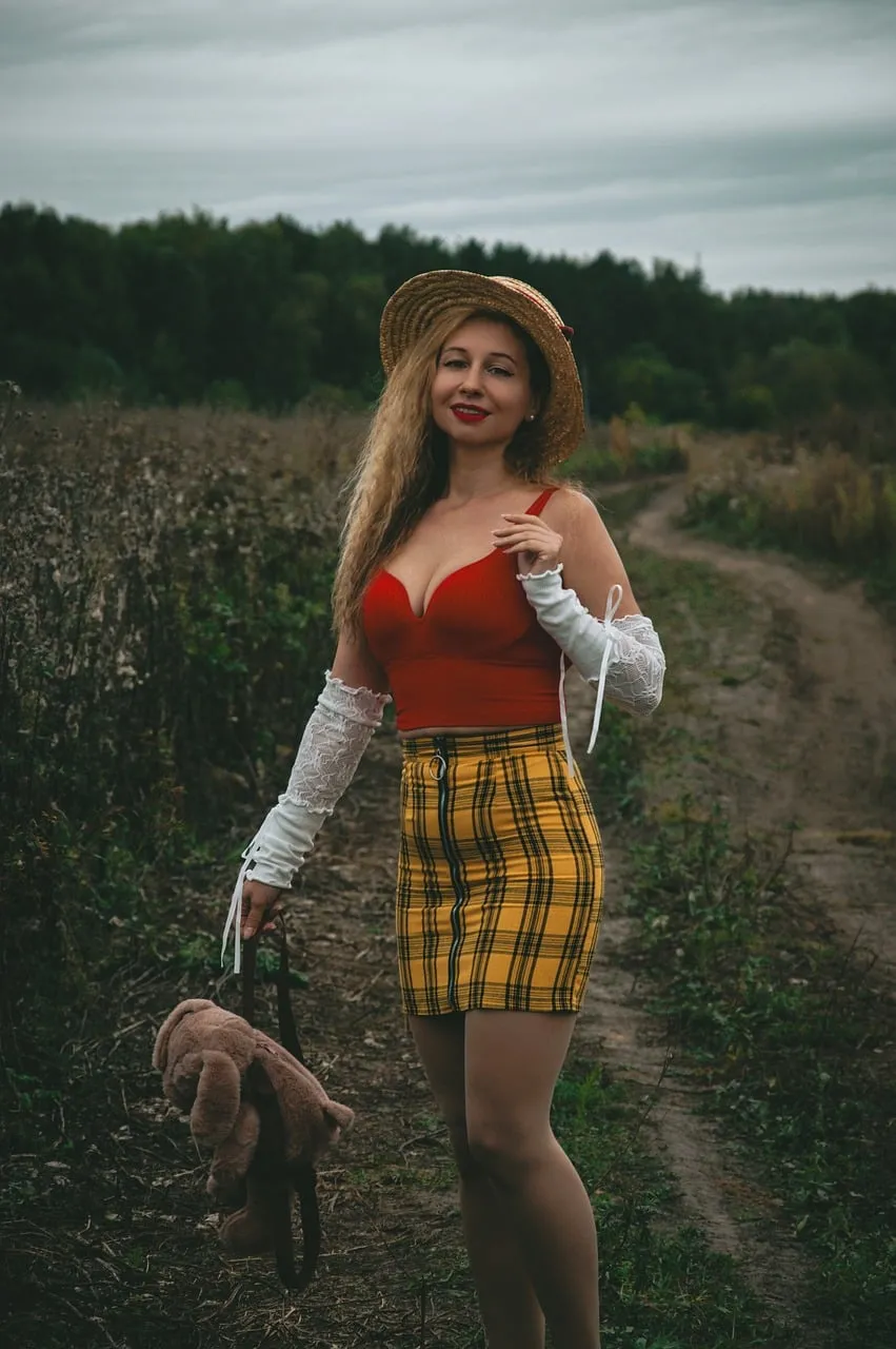 Enchanting Autumn Fashion: Blonde Model in Plaid Skirt on a Rustic Path