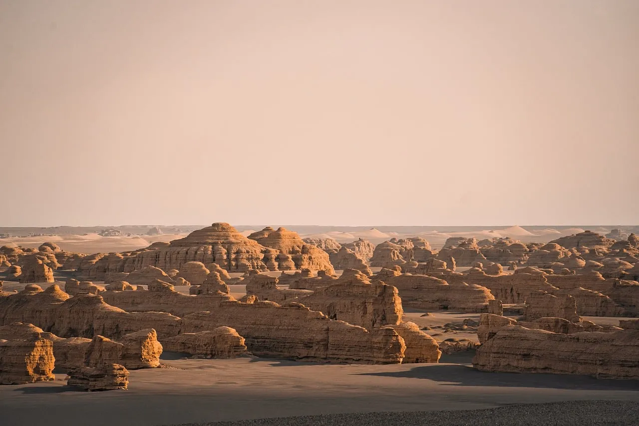 Dramatic Desert Sunset: Ancient Rock Formations Bathed in Warm Light