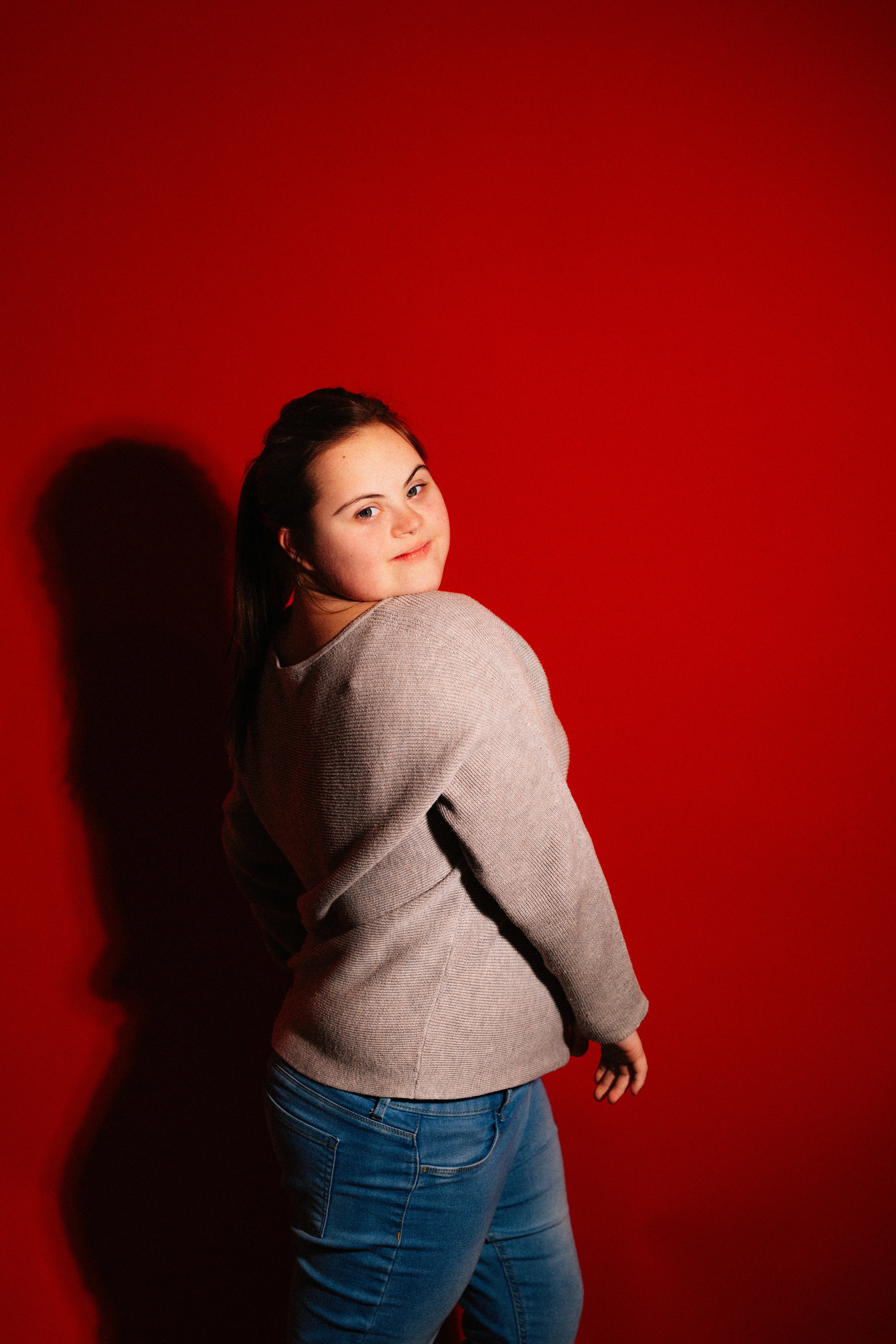 Empowered Beauty: Young Woman with Down Syndrome against Red