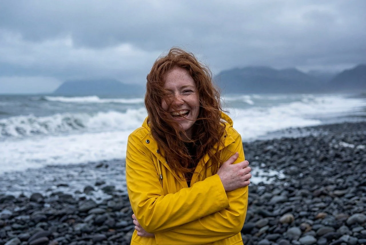 Joyful Redhead Braves Stormy Beach in Vibrant Yellow Raincoat