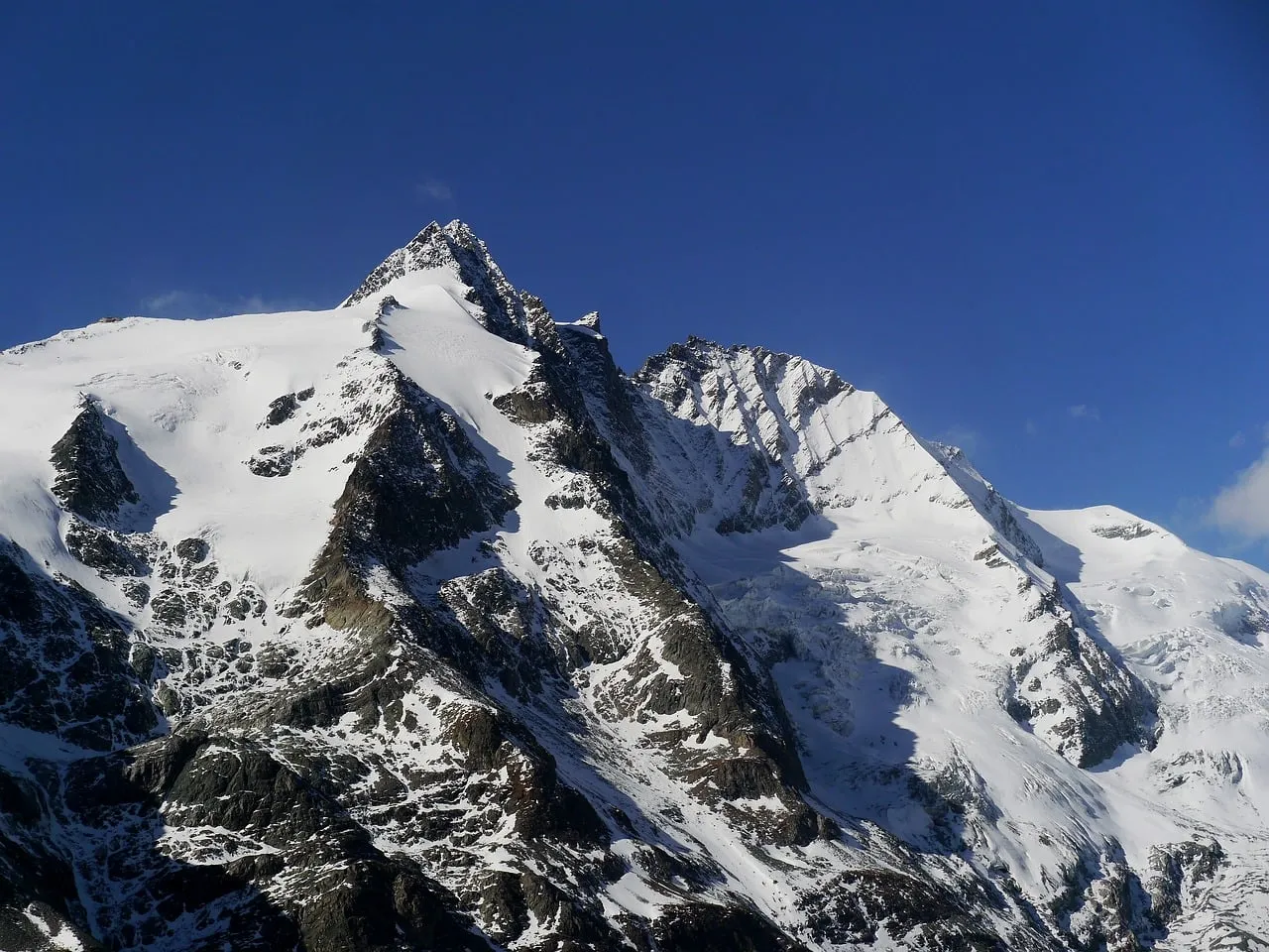 Majestic Alpine Peaks: Snow-Covered Grandeur Under a Blue Sky