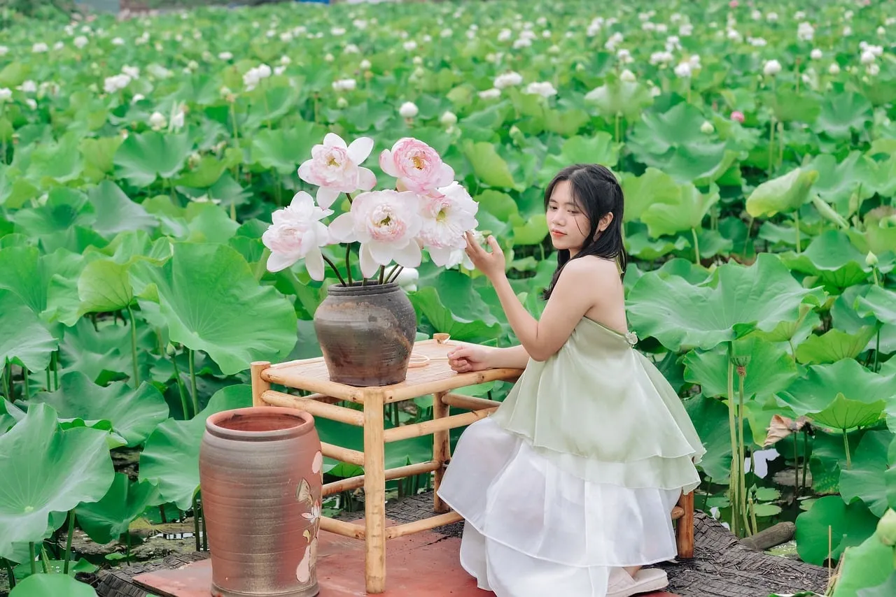 Serene Beauty: Woman Amidst Lush Lotus Garden