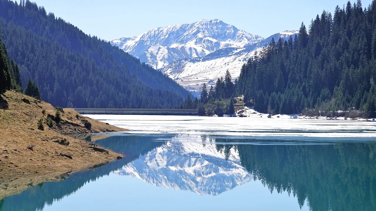 Stunning Alpine Panorama: Snow-Capped Peaks Reflected in Tranquil Lake
