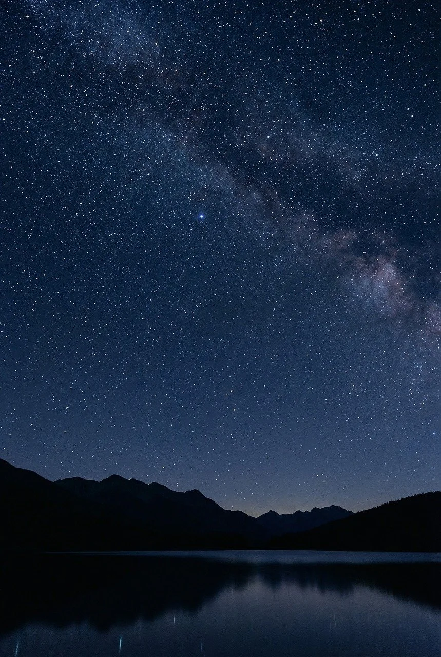 Celestial Abyss: Milky Way's Reflection Over Serene Mountain Waters