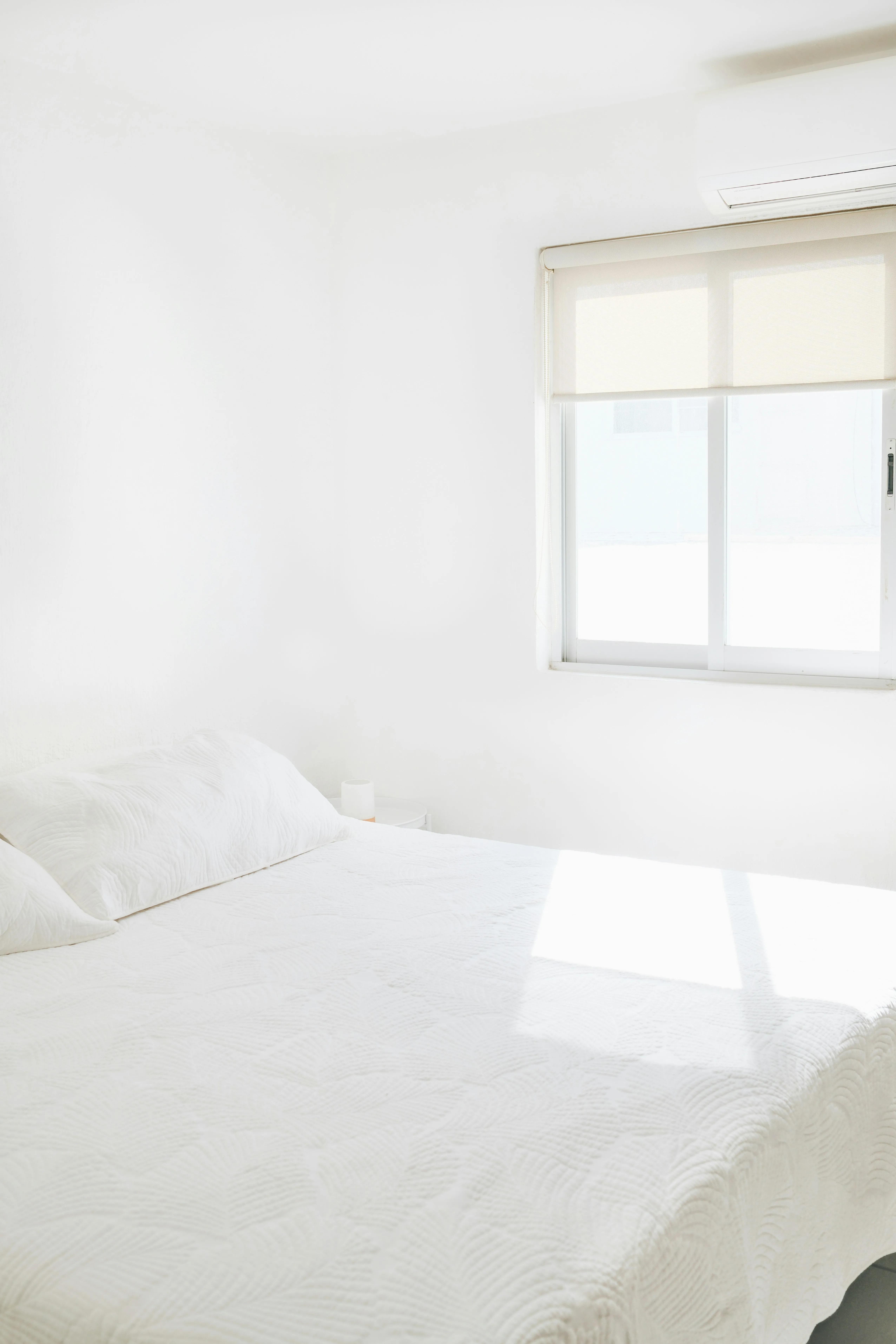 Minimalist White Bedroom Bathed in Bright Sunlight