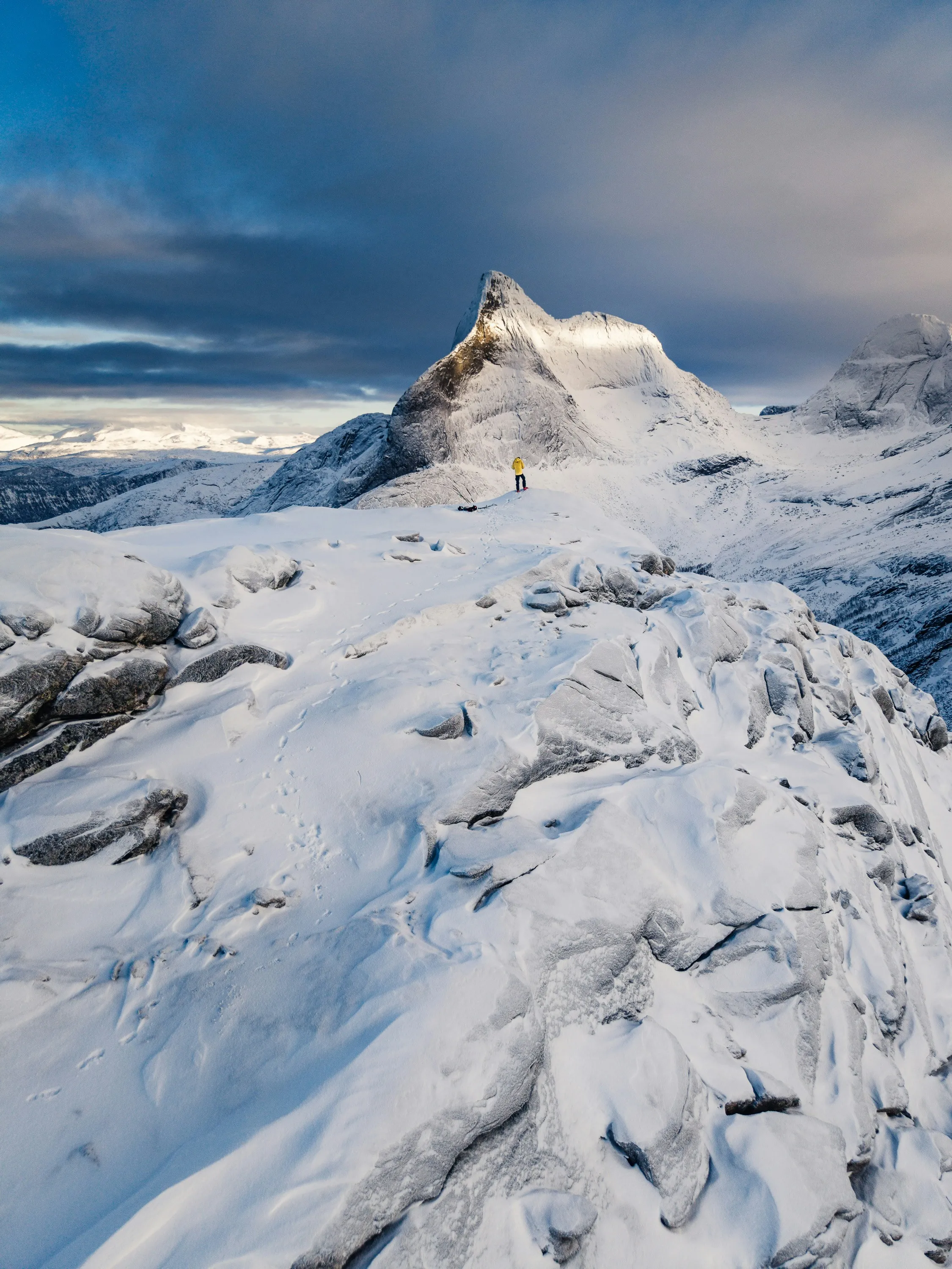 Majestic Winter Ascent: Solitary Hiker on a Snowy Peak