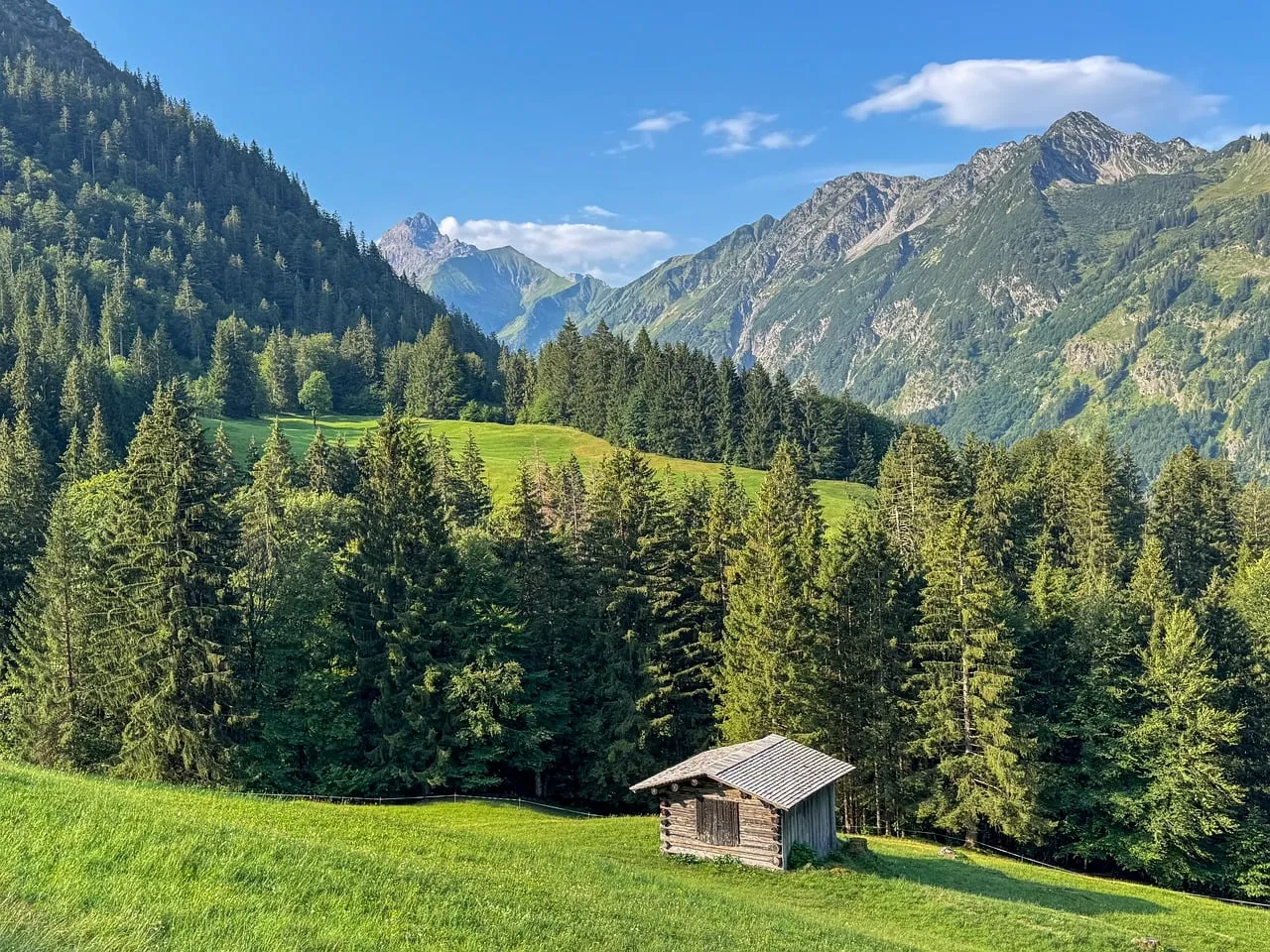 Serene Alpine Morning: Tranquil Hut Amidst Majestic Peaks