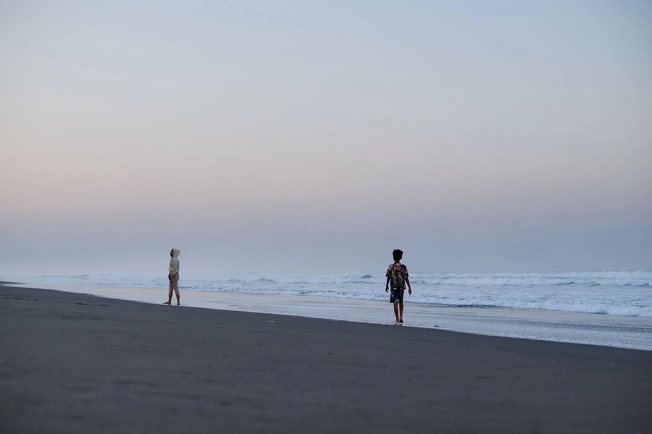 Serene Dawn: Children's Play on Volcanic Sand Beach