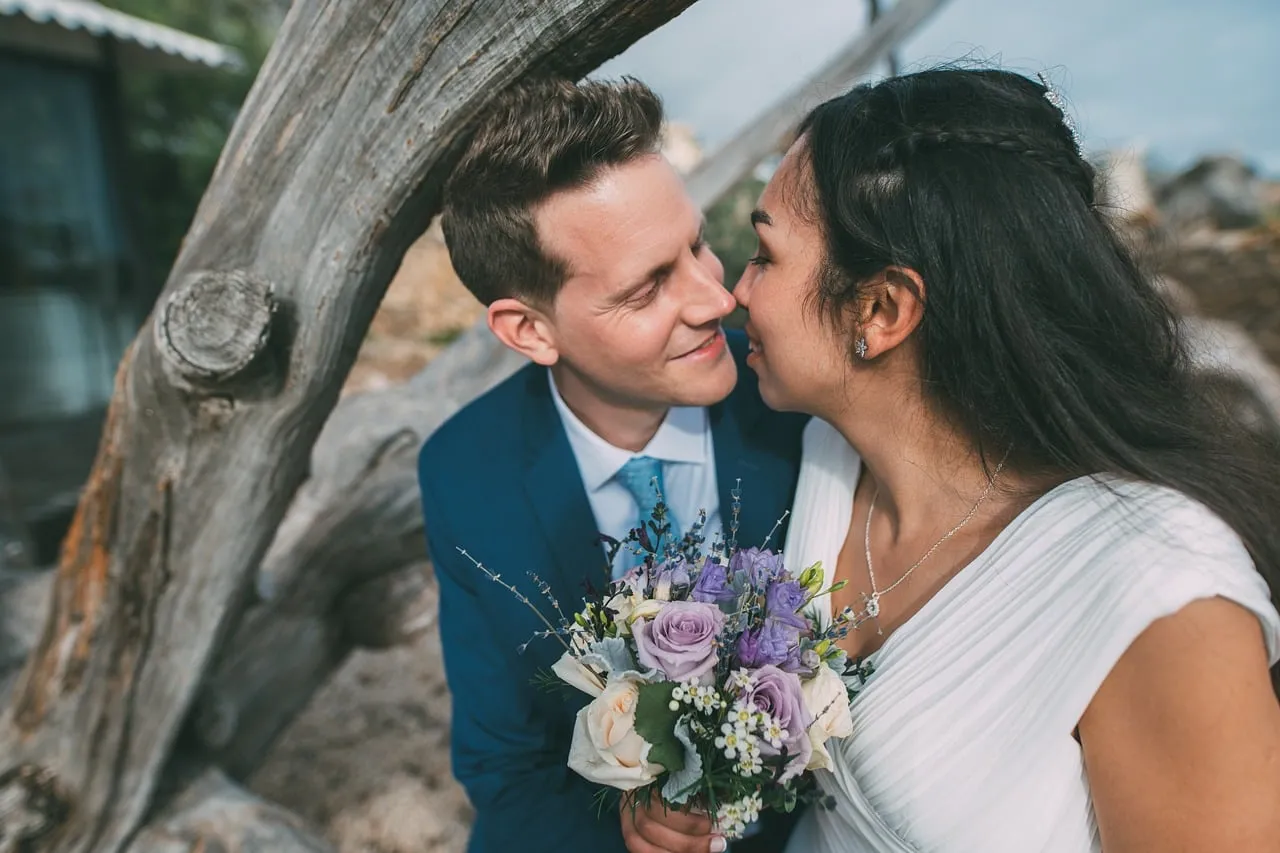 Enchanting Beach Wedding: A Tender Kiss Amidst Nature's Beauty