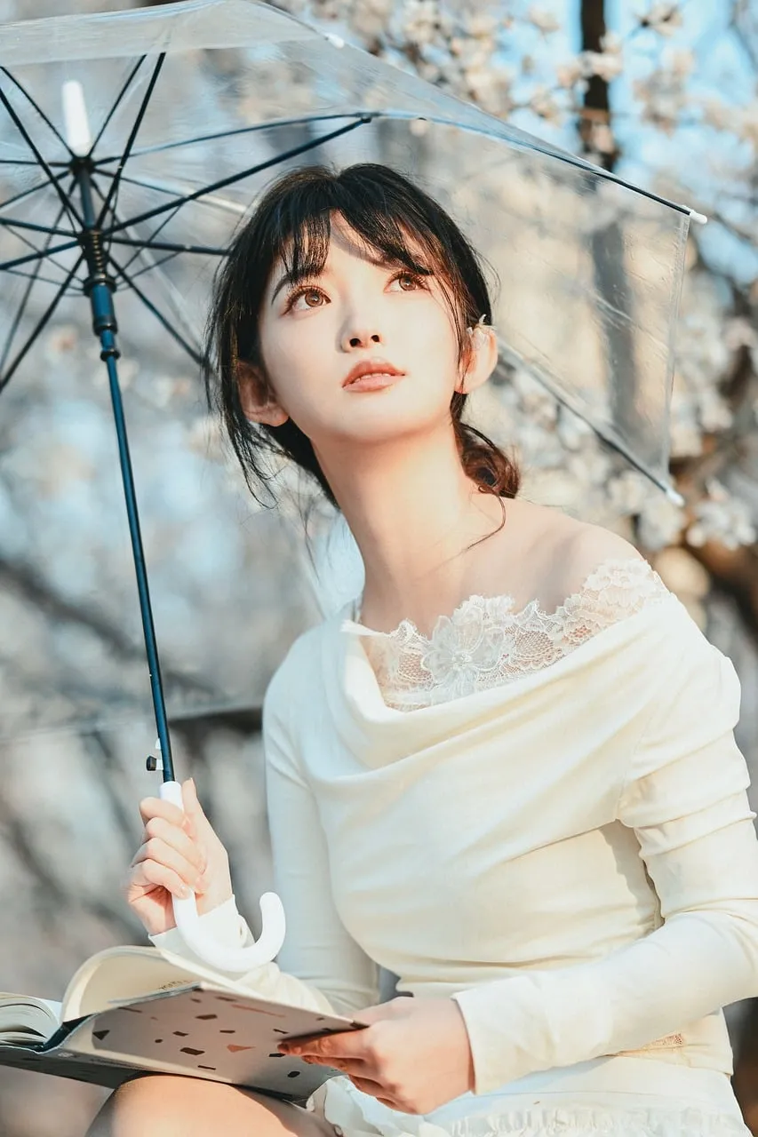 Enchanting Spring Blossom Portrait: Woman with Umbrella and Book