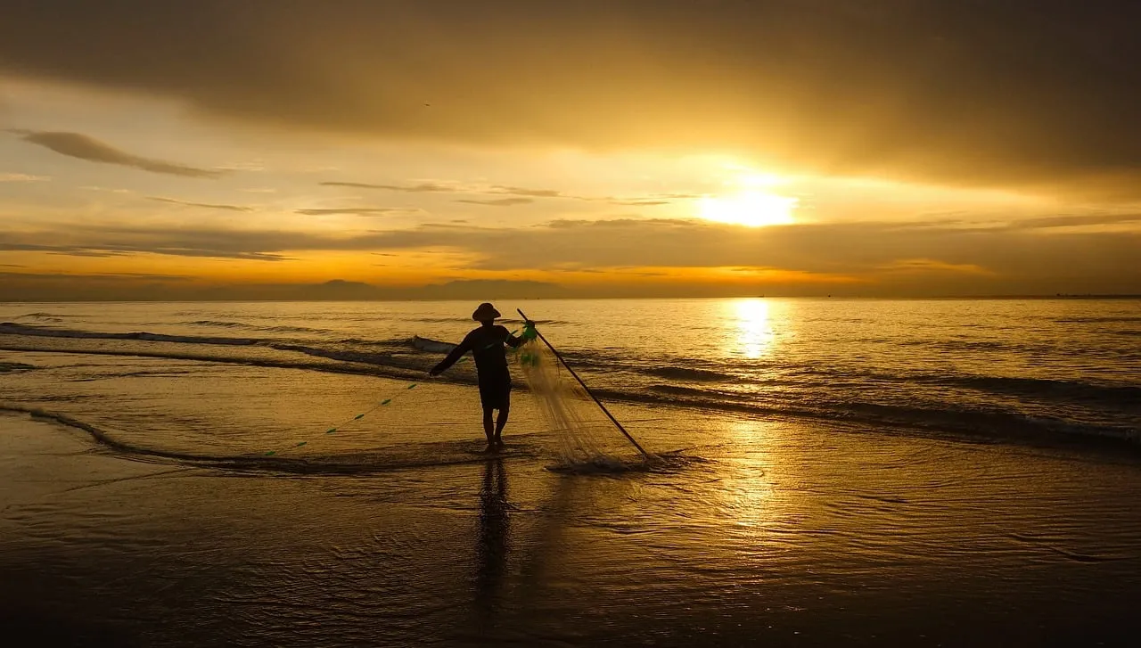 Golden Dawn: Fishermen Cast Nets on Tranquil Beach