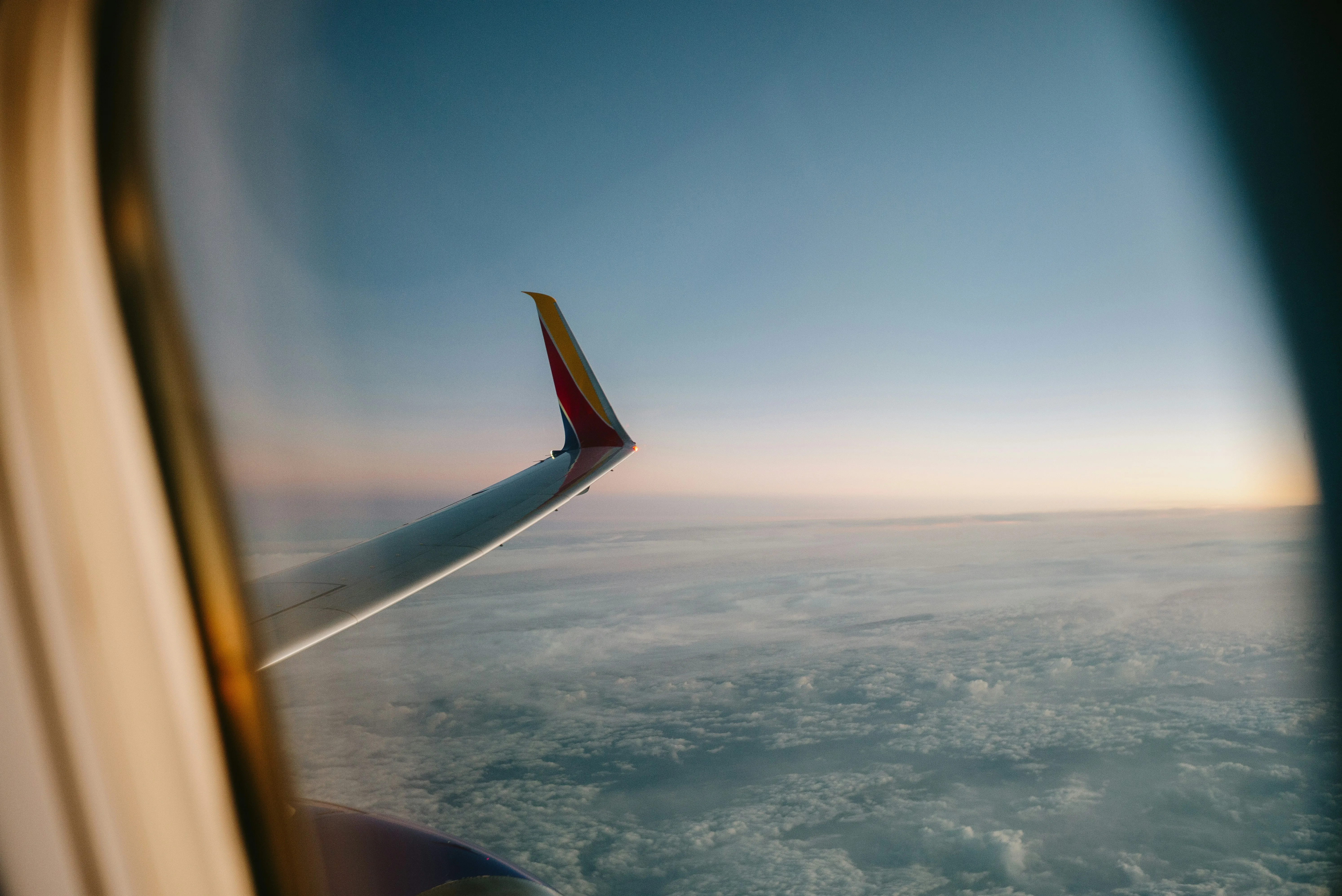 Breathtaking Sunset Flight: Wing Above the Clouds