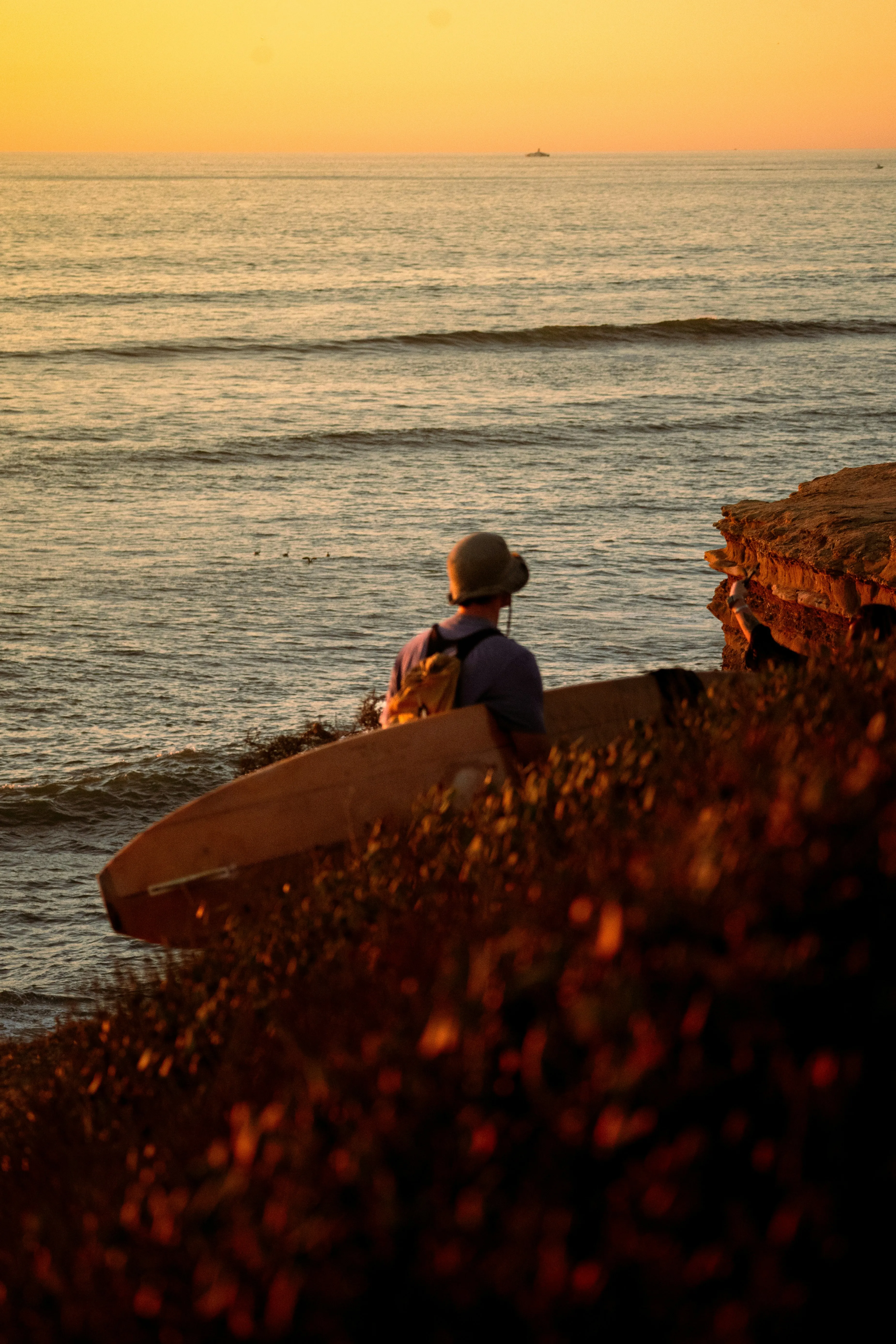 Golden Hour Serenity: Surfer Gazing at Ocean Sunset