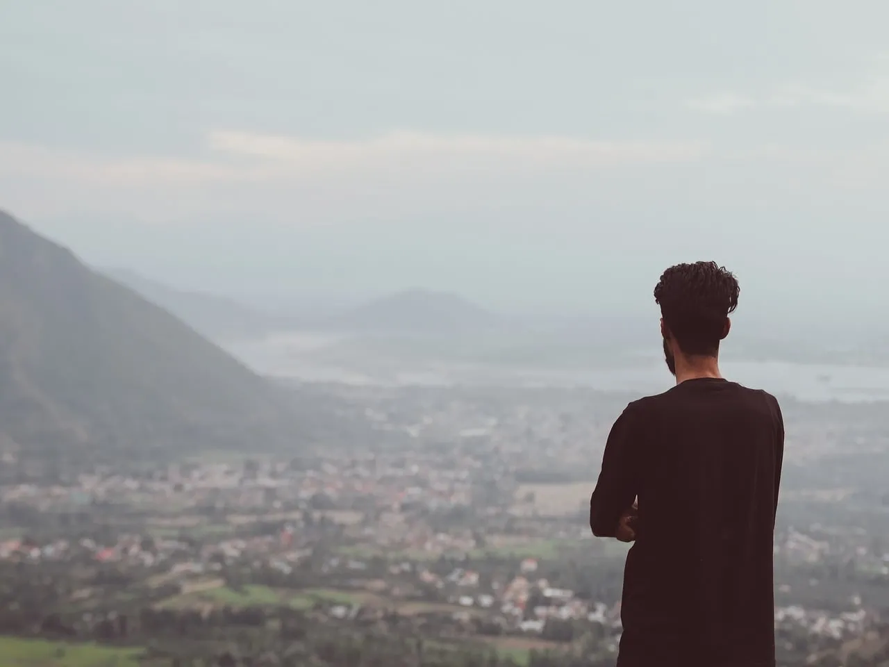 Breathtaking Mountain Vista: Man Reflects in Solitude