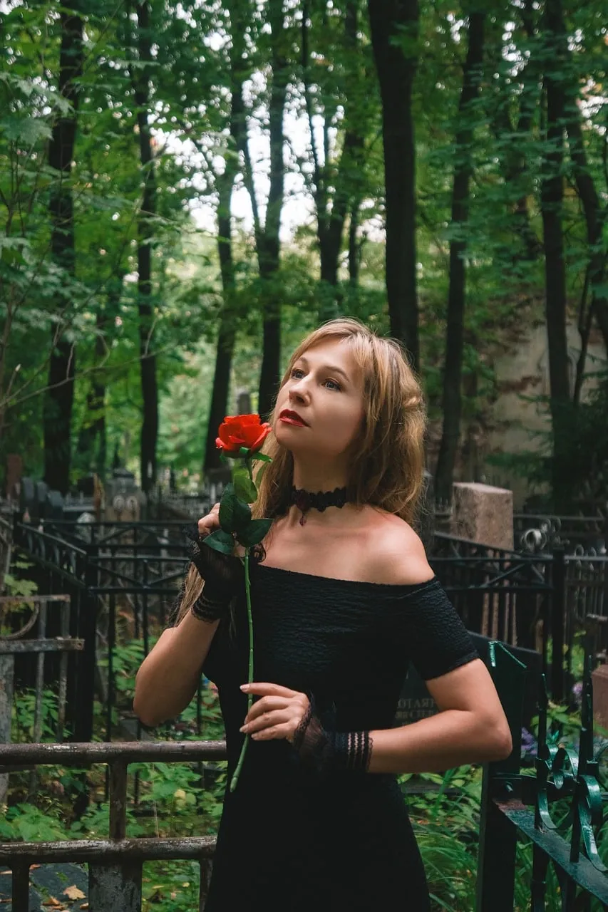 Enigmatic Gothic Beauty with a Red Rose in a Mystical Forest
