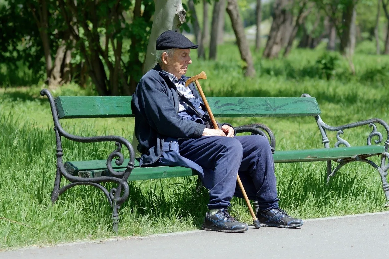 Serene Moment: Elderly Man Rests Peacefully in Spring Park