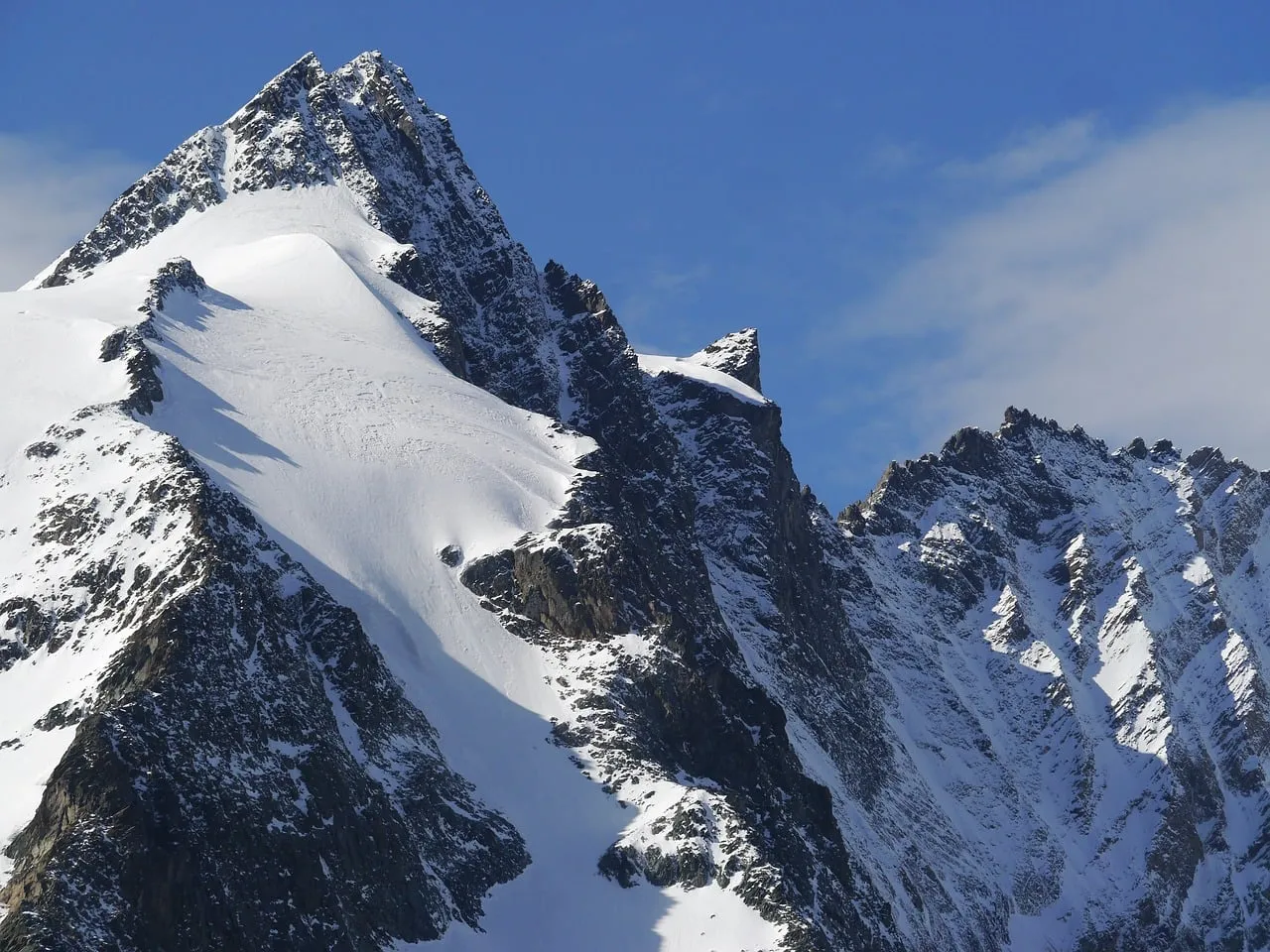 Breathtaking Alps: Majestic Snow-Capped Peak Under Blue Sky