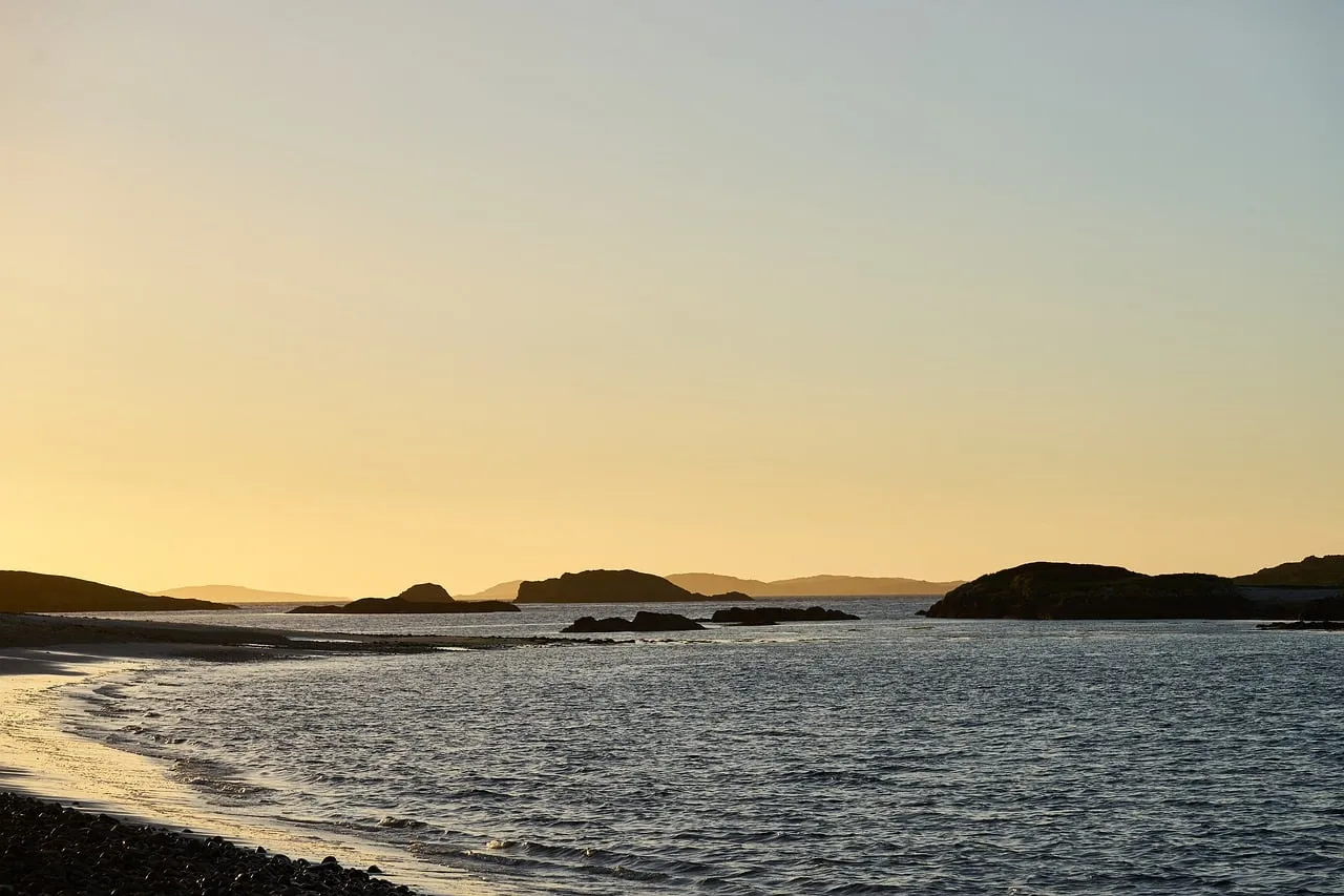 Serene Sunset: Tranquil Ocean View with Silhouetted Islands