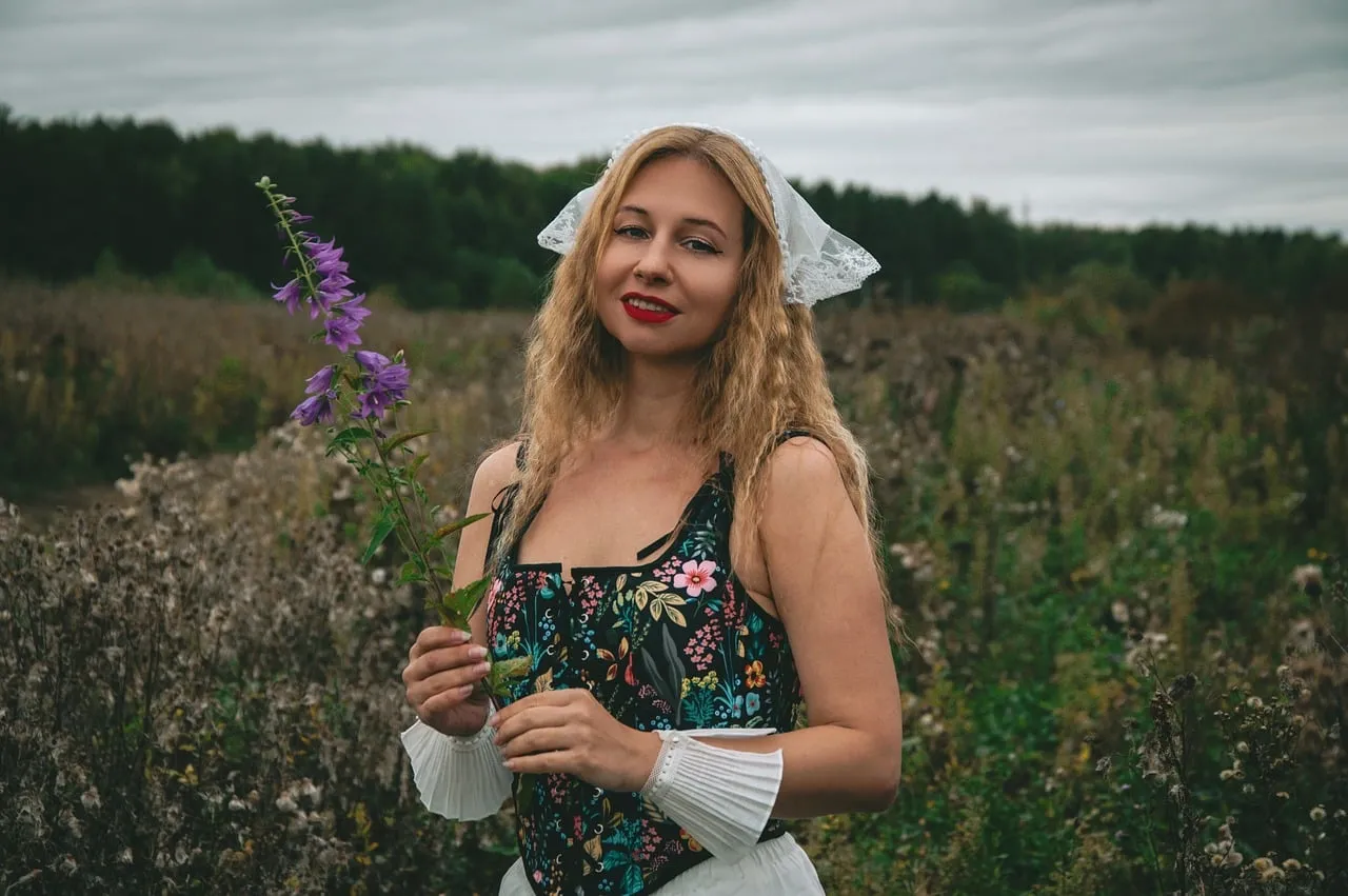 Enchanting Autumn Portrait: Blonde Woman in Floral Corset Amidst Wild Meadow