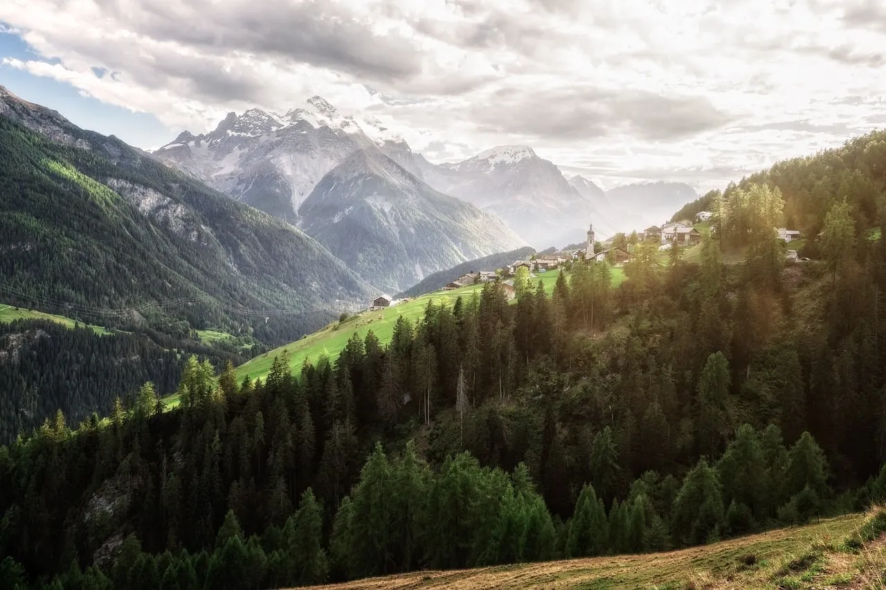 Breathtaking Alpine Panorama: Village Nestled Amidst Majestic Peaks