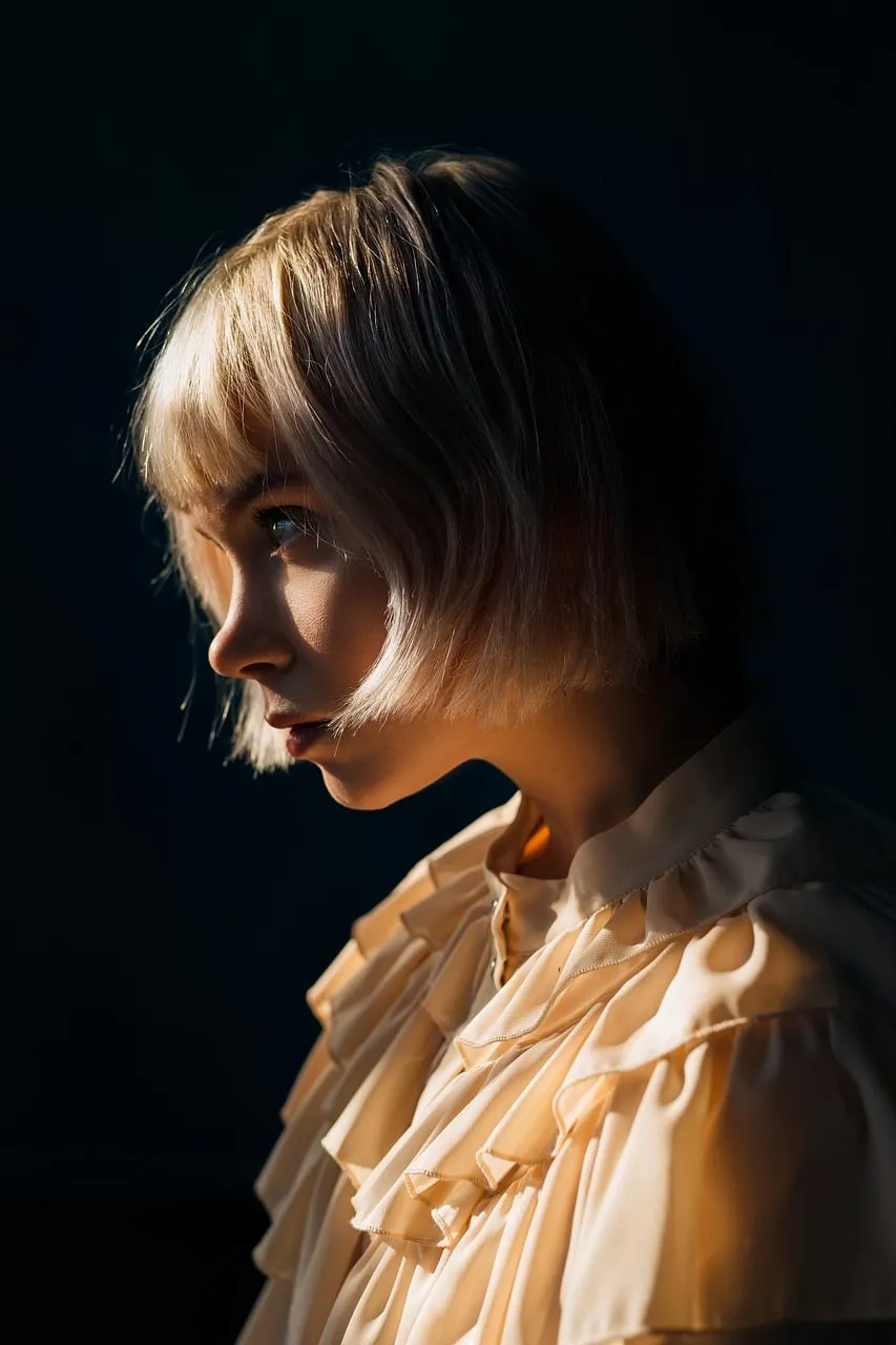 Stunning Light Play: Emotive Blonde Portrait on Dark Background