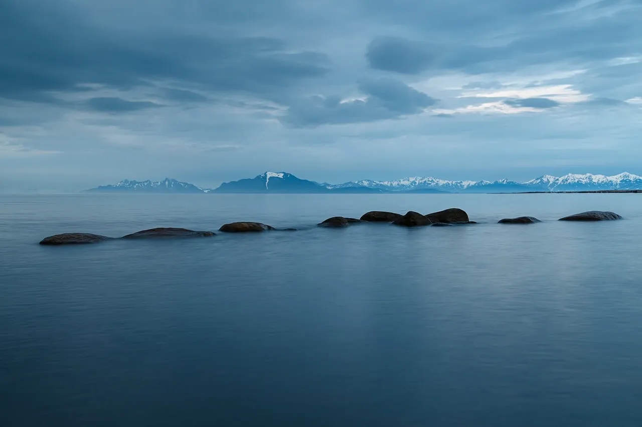 Serene Winter Seascape: Snow-Capped Mountains and Calm Waters