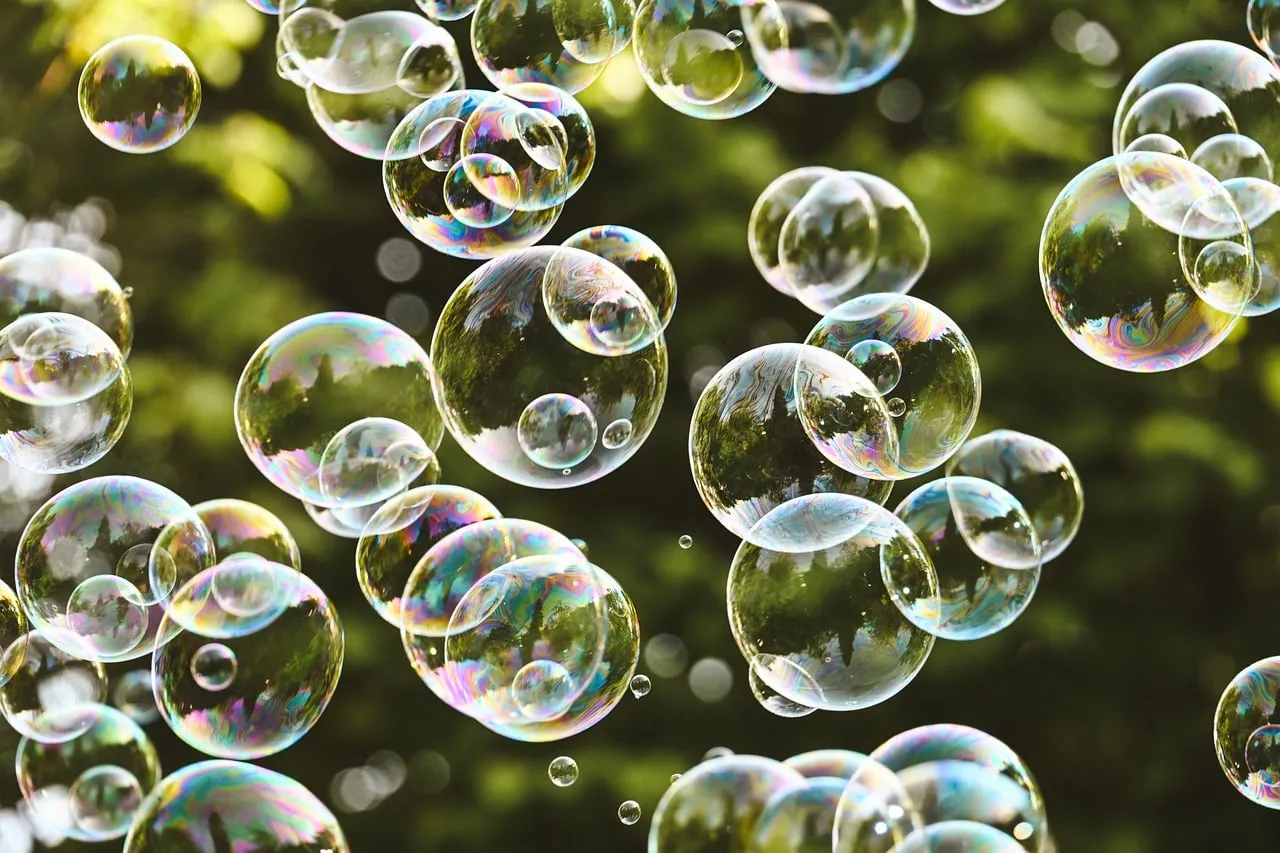 Vibrant Iridescent Bubbles Floating Against Green Foliage
