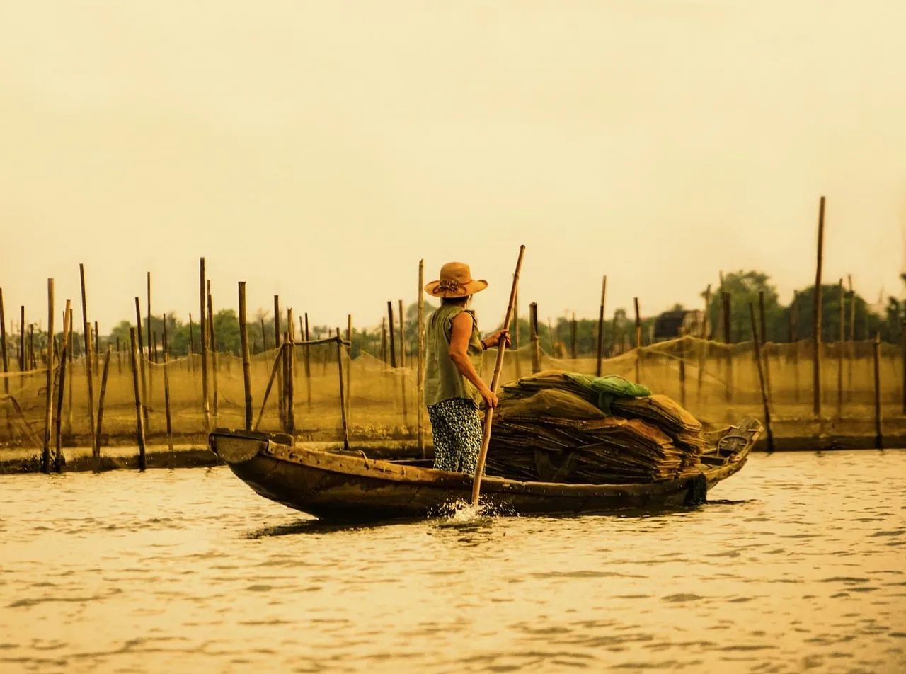 Serene Sunset: Traditional Vietnamese Fisherman on Lagoon