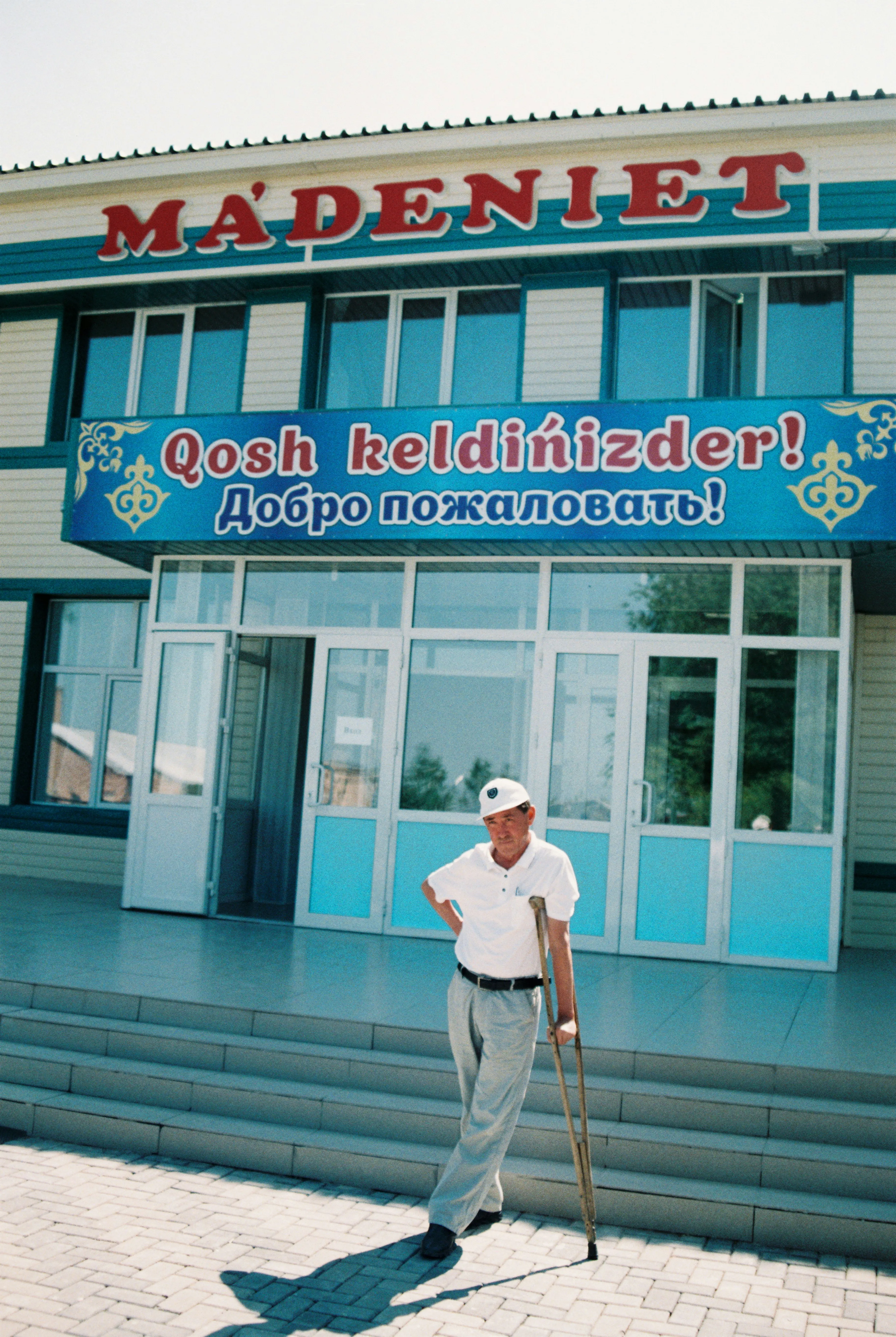 Resilient Spirit: Elderly Man with Crutches Outside a Building